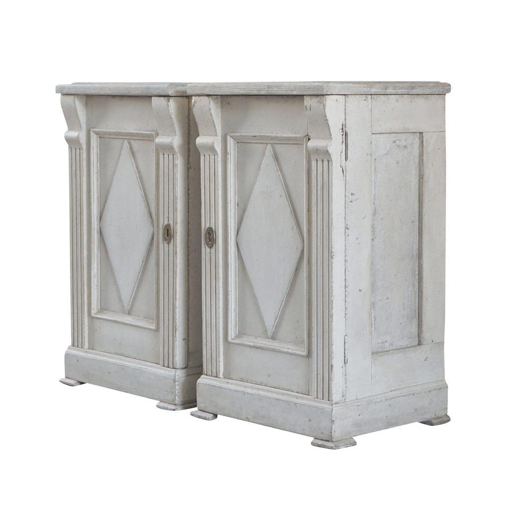A light-white, antique pair of Swedish Gustavian bedside tables made of hand carved pinewood, each is featuring a faux marble hand painted top with one drawer, in good condition. The Scandinavian nightstands are detailed in the Neoclassical Greek