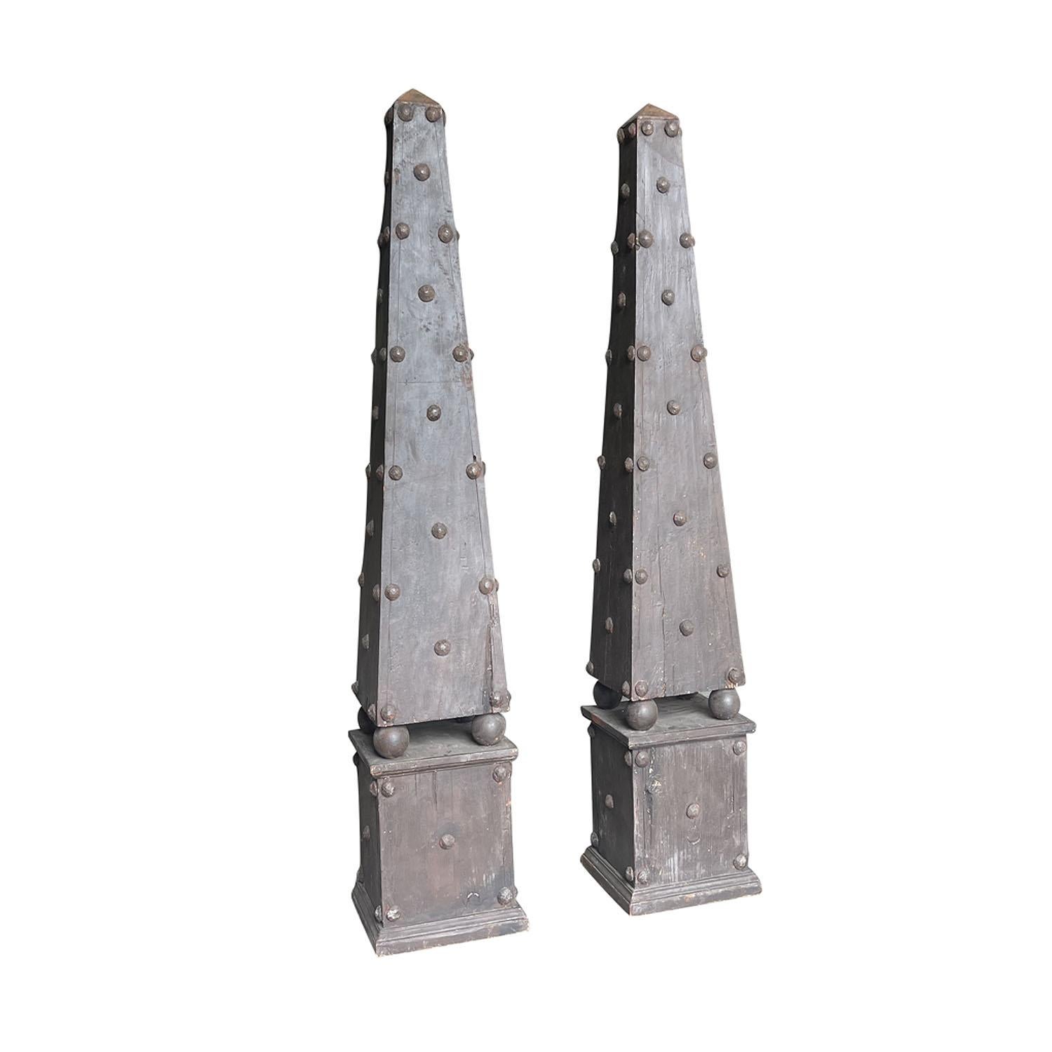 Paire d'obélisques suédois gustaviens anciens du début du 19e siècle en bois de pin, en bon état. Chacune est recouverte d'ornements décoratifs ronds martelés à la main. Les éléments architecturaux rustiques scandinaves reposent sur quatre sphères