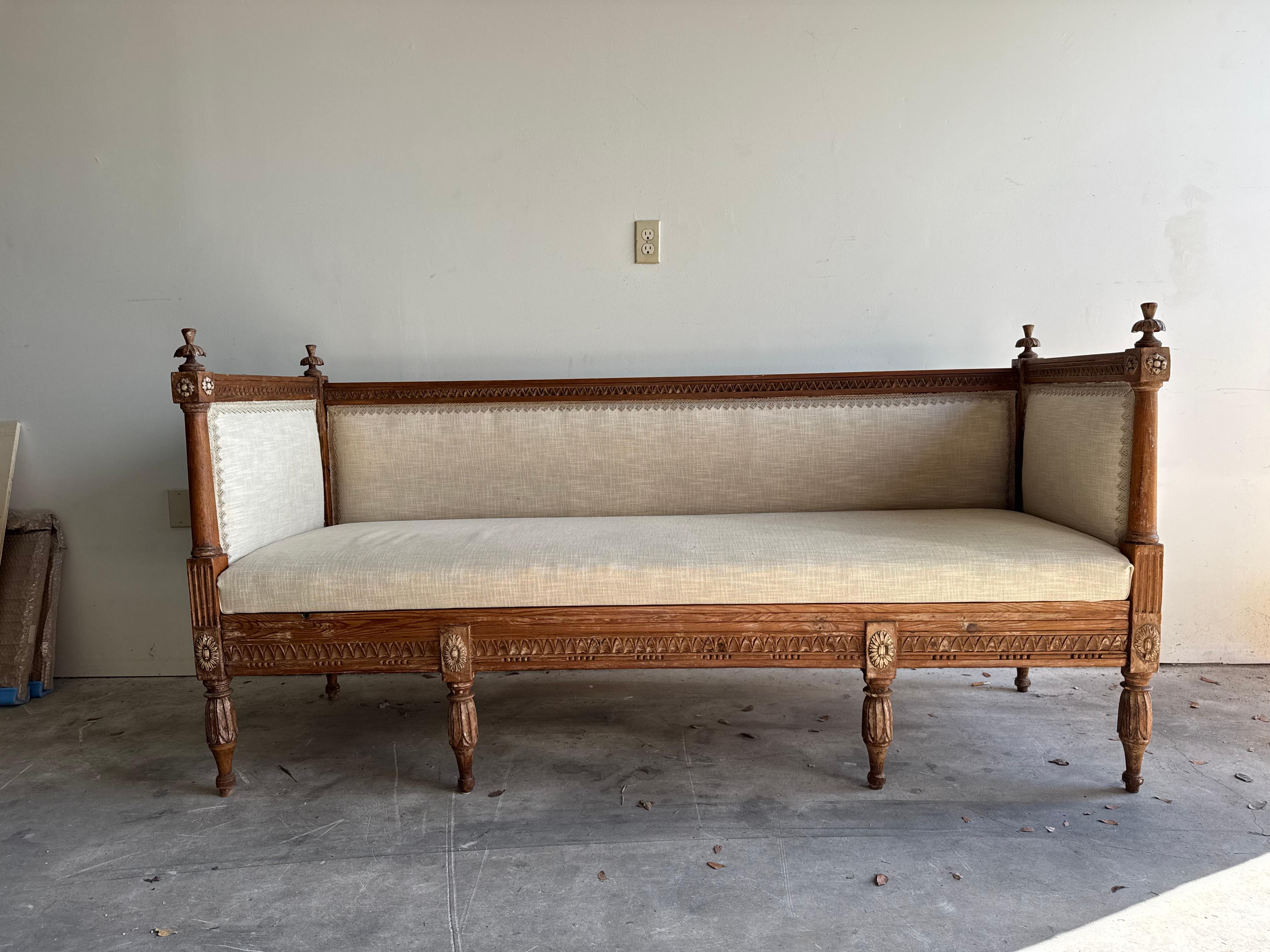 Refinado sofá cama sueco de estilo Gustaviano de finales del siglo XIX, de madera de pino tallada a mano, en buen estado original. Este elegante sofá antiguo refleja las características distintivas de la estética gustaviana: ligereza, equilibrio y