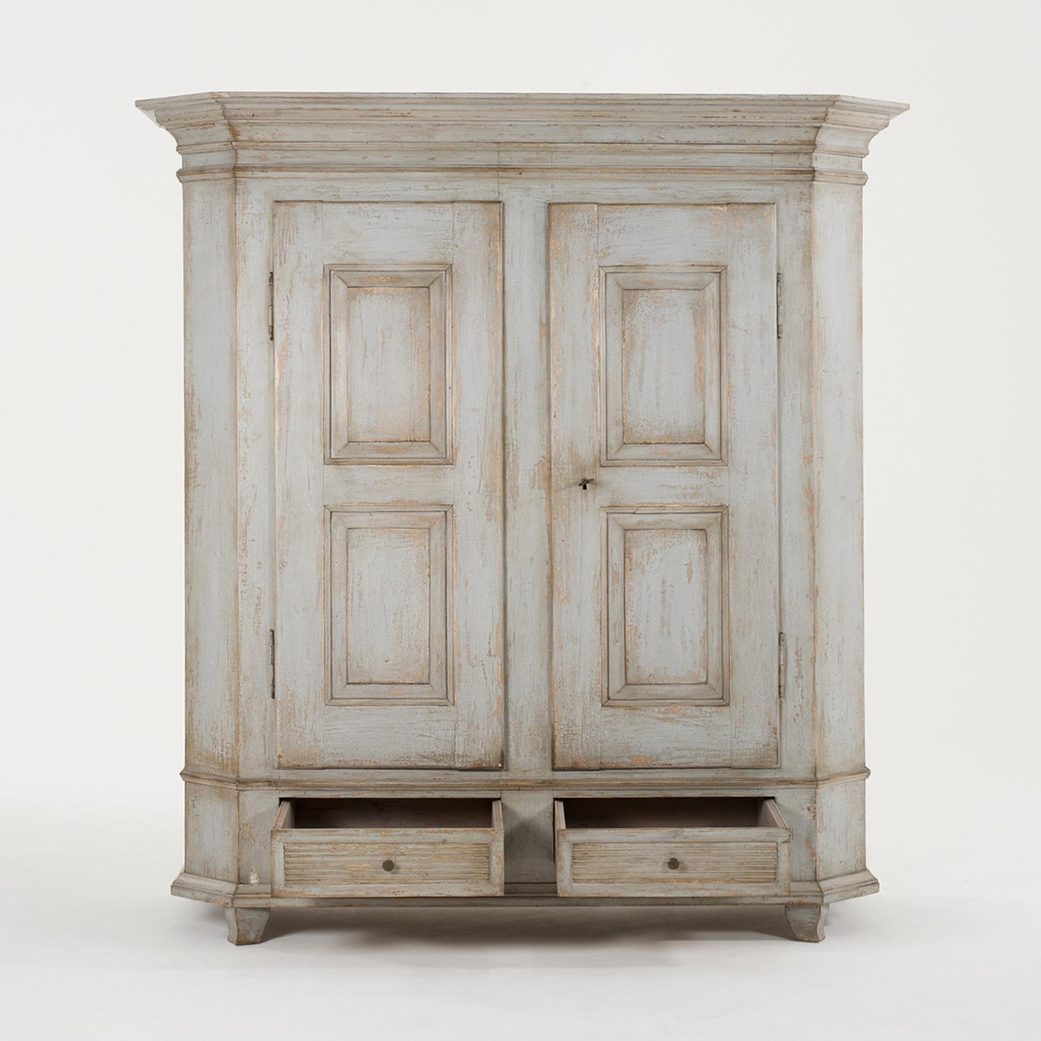 A blue-grey, antique Swedish Gustavian armoire, wardrobe made of hand crafted painted Pinewood, in good condition. The tall Scandinavian cabinet is composed with two doors and two lower drawers, detailed with round door pulls, handles, supported by