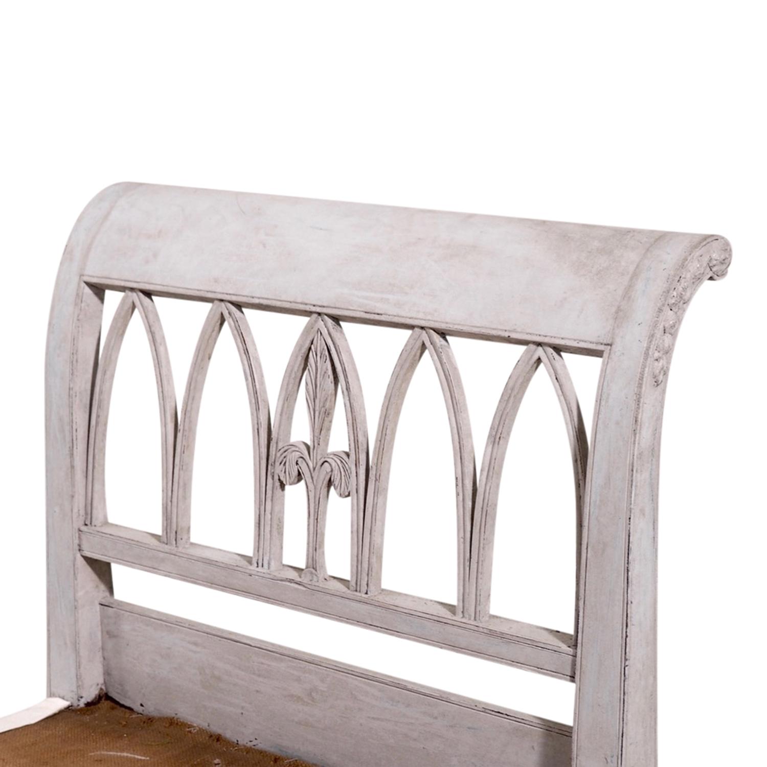 An early 19th Century, antique Swedish Gustavian daybed made of hand crafted painted Pinewood, in good condition. The side rests of the Scandinavian Lit Du Jour are enhanced by unique wood carvings, standing on eight curved wooden feet. The wood