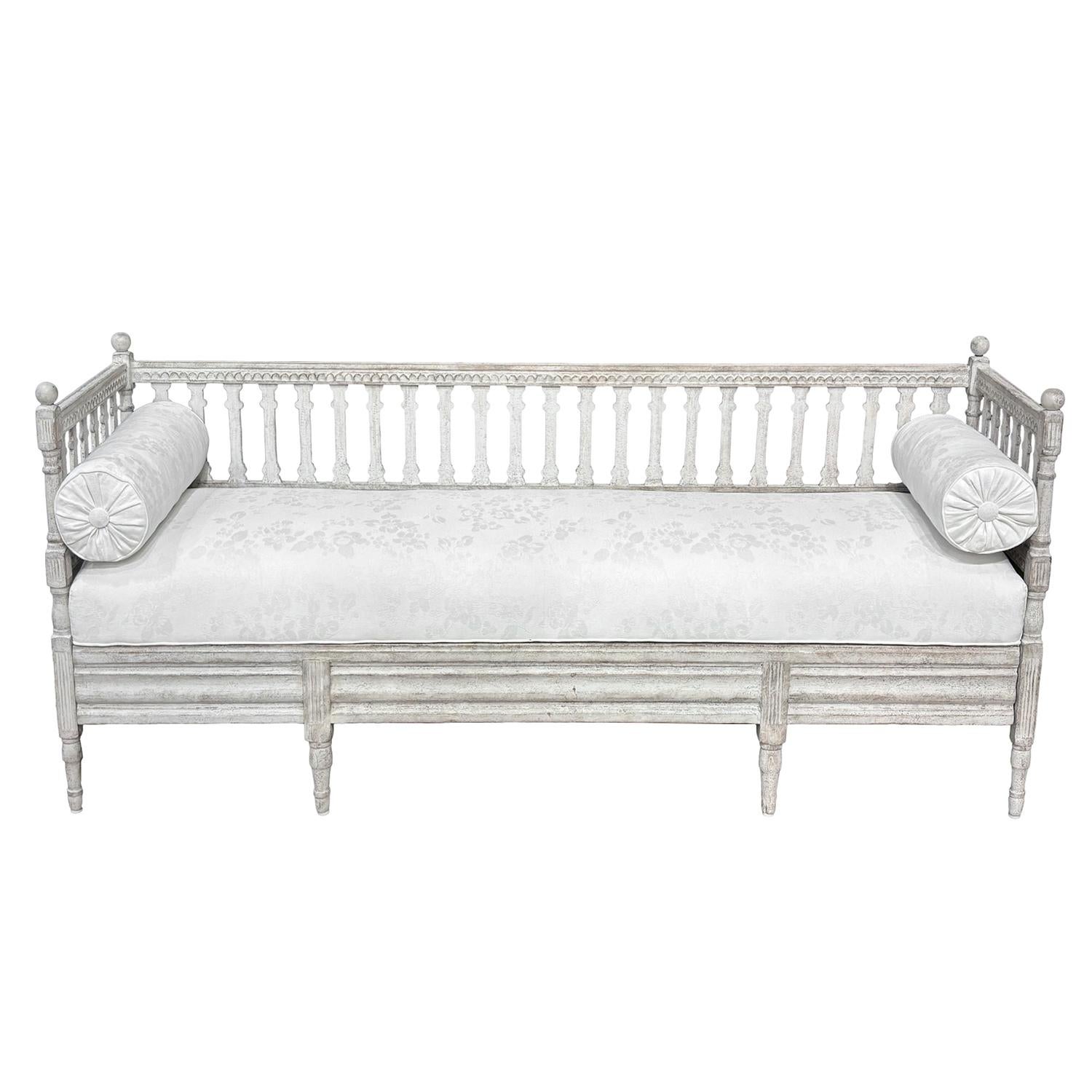 A late 19th Century, antique Swedish Gustavian pull-out daybed made from hand crafted painted Pinewood, in good condition. This freestanding Scandinavian wood bench features a tall spindle back and gently curved side rests, all supported by eight