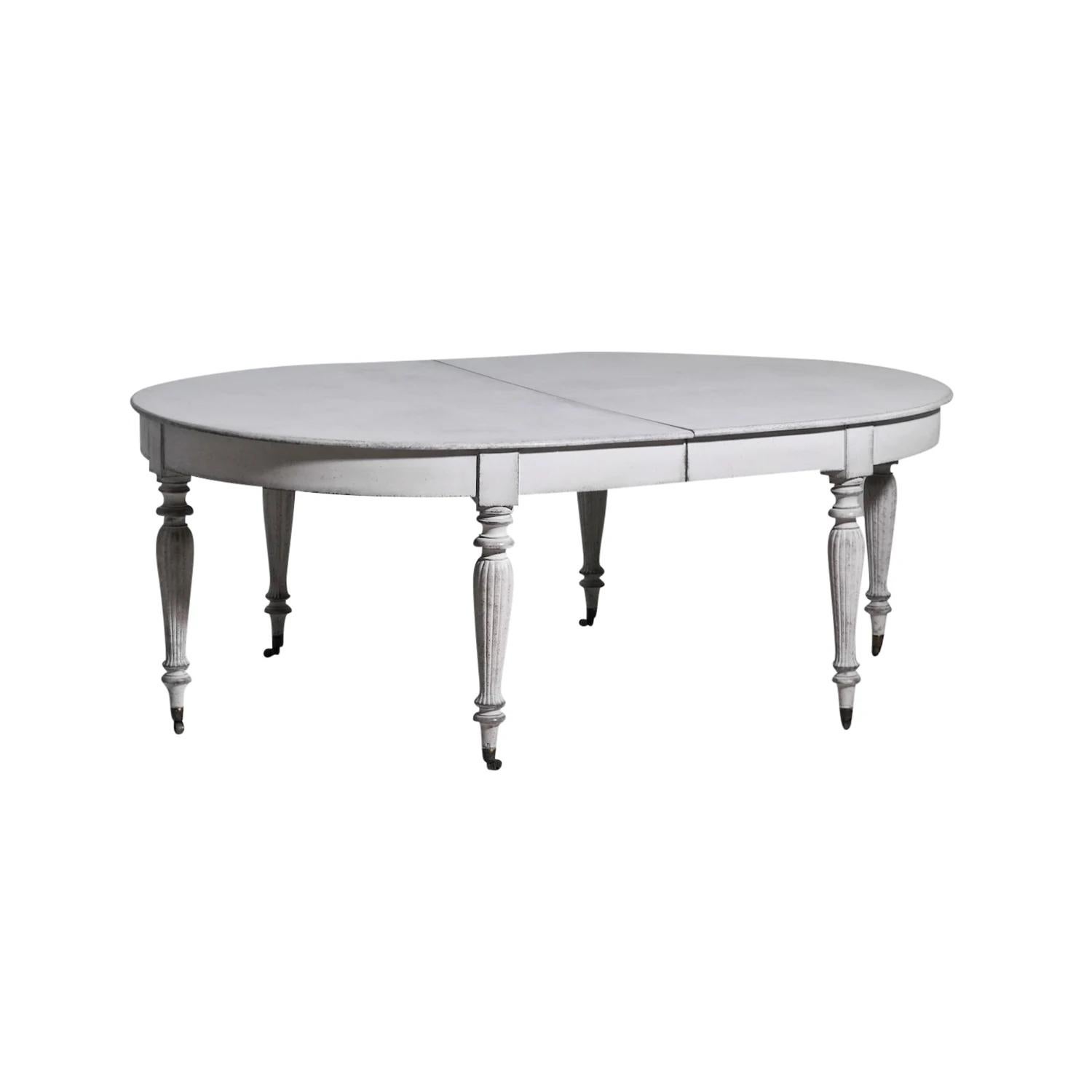 A light-grey, antique Swedish Gustavian extendable dining room table made of hand crafted Pinewood with two leaves and apron. The Scandinavian half round table is standing on six round tapered fluted legs, supported by brass wheels, detailed in the