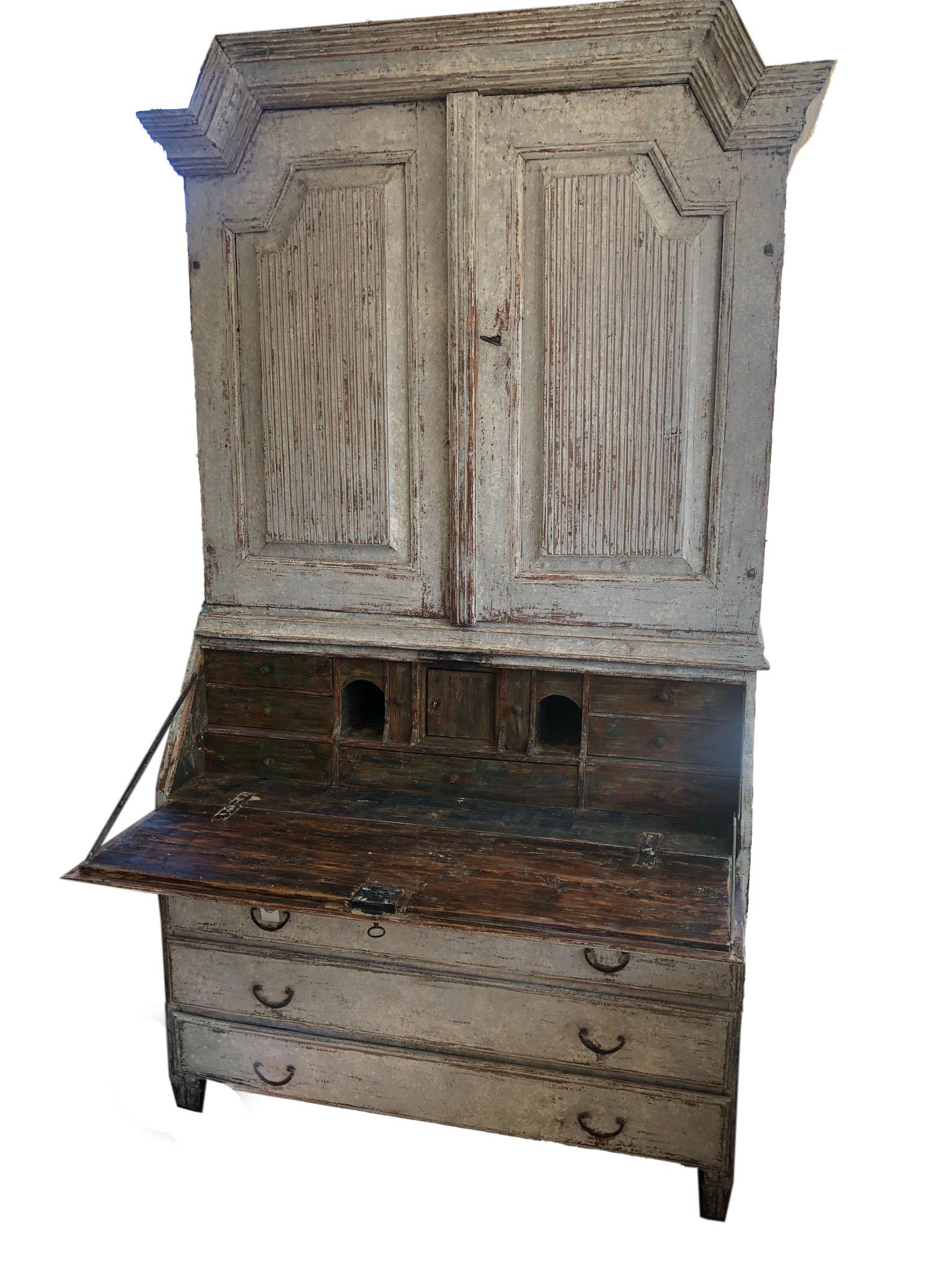 This is an exquisite Swedish Gustavian period painted secretary with library. Brass hardware and original locks, circa 1820. The upper section has three shelves, behind shaped and reeded door. The lower section has a slant front. The finish shut it