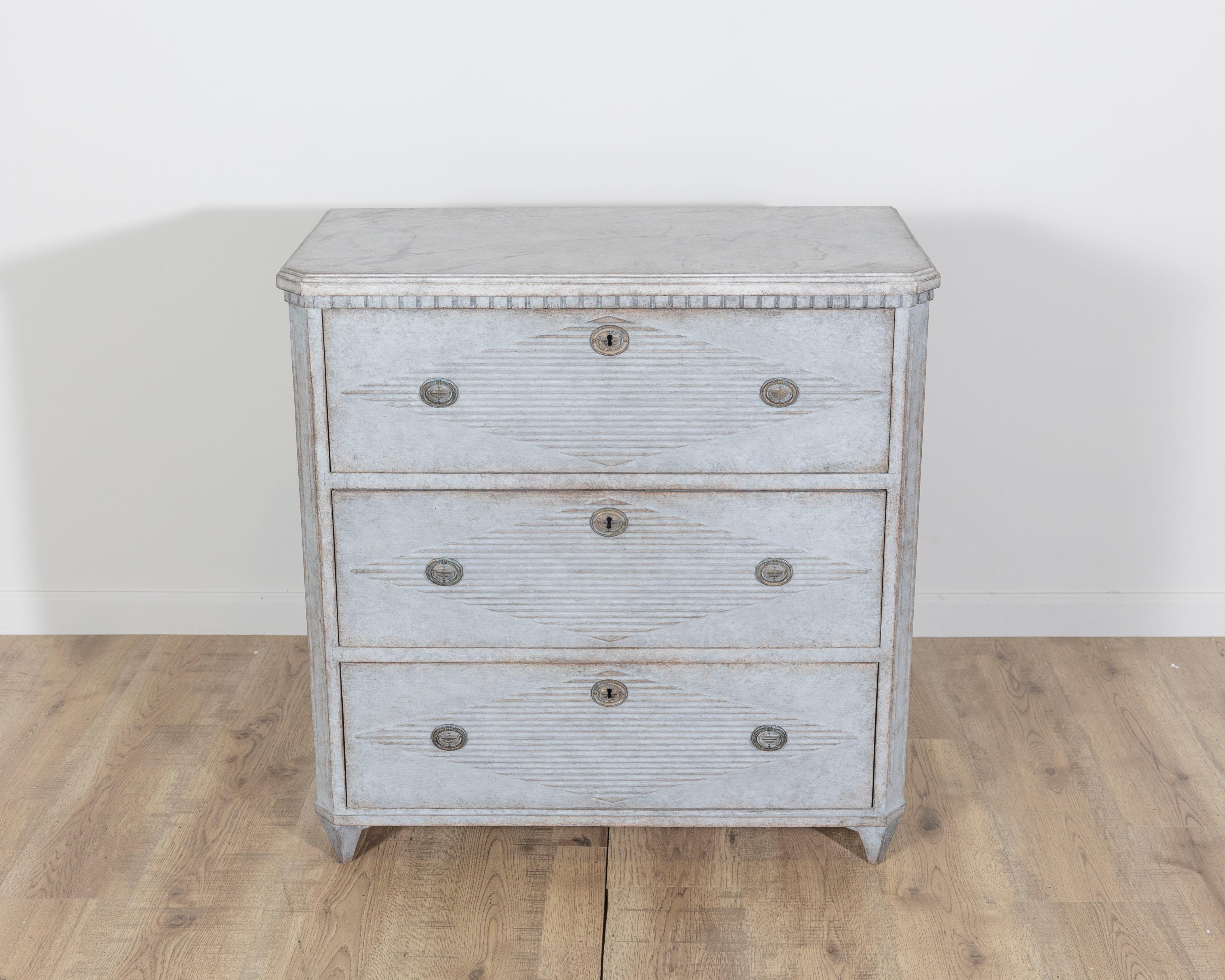 This elegant 19th-century Swedish chest of drawers, crafted circa 1870, is a fine example of the Gustavian style, an aesthetic born from neoclassical influences and adapted with Scandinavian restraint. The chest features three full-length drawers,