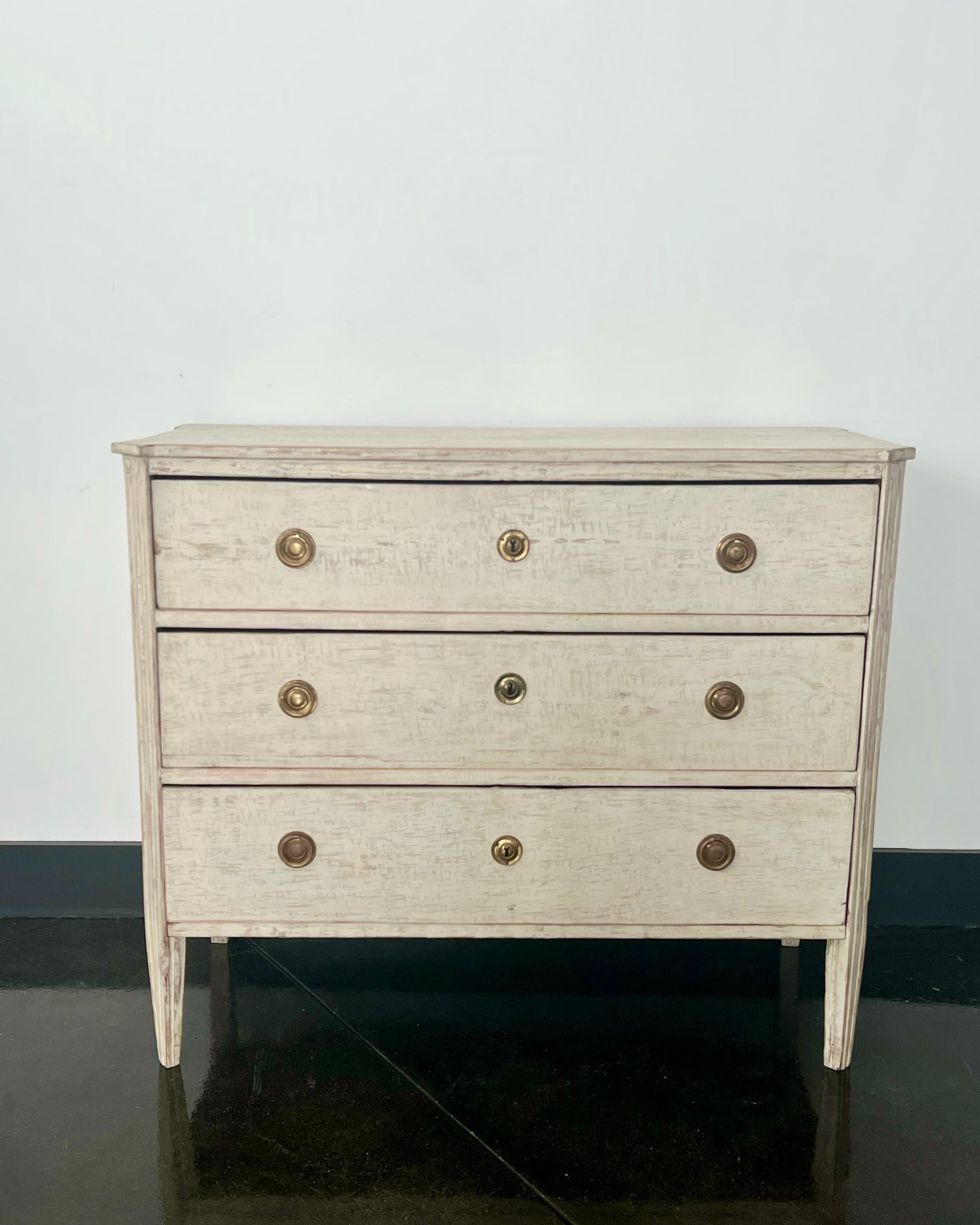 19th Century Swedish Gustavian style chest of drawers with three drawers, canted and reeded corners, handsome bronze hardwares and tapering square legs under the shaped wooden top in most of its original finish.

