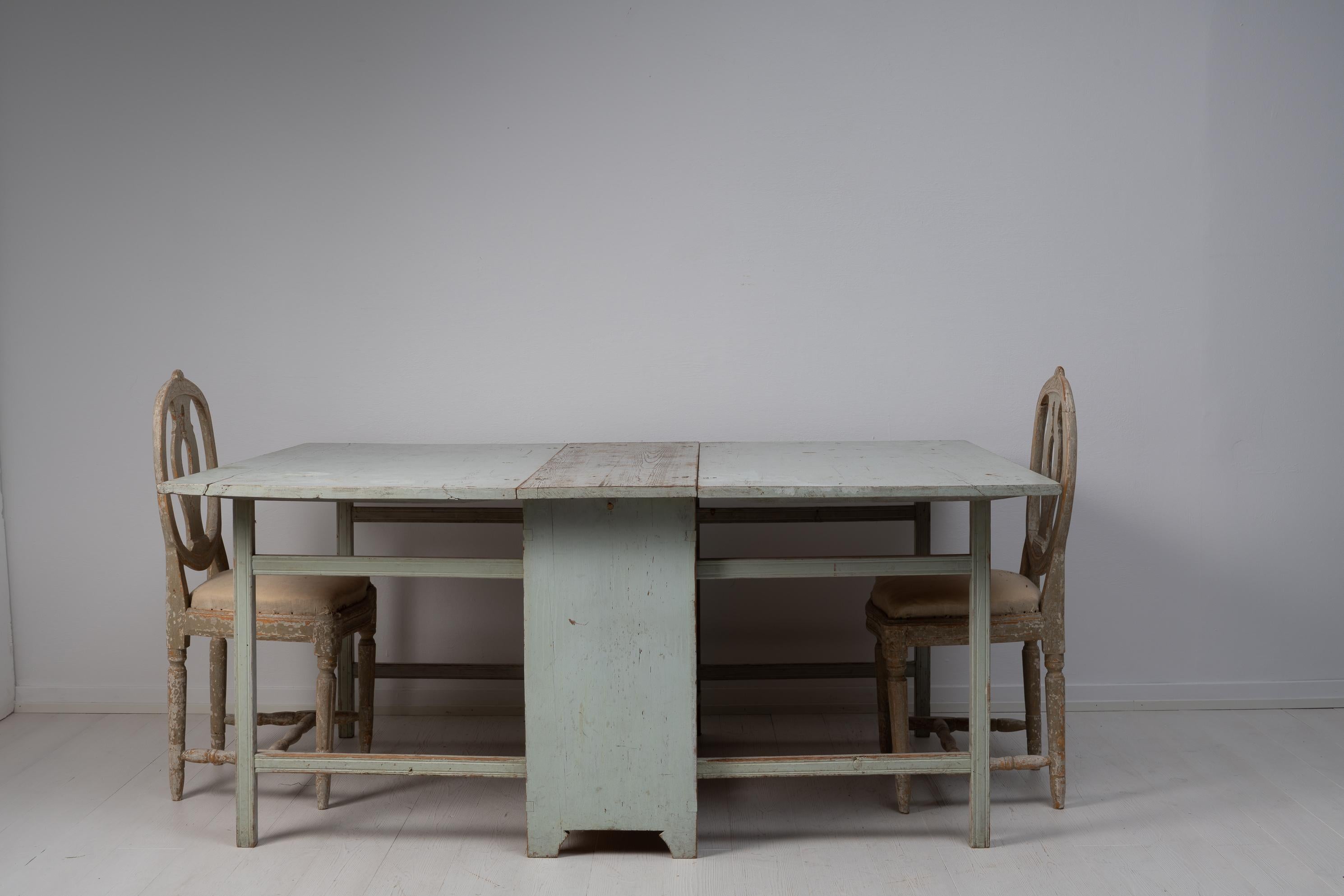 Drop leaf table in gustavian style made around 1810 in northern Sweden. The table is hand-made in Swedish pine and painted in a light grey tone. The paint is the original first layer of paint from the early 1800s. The table is in untouched original