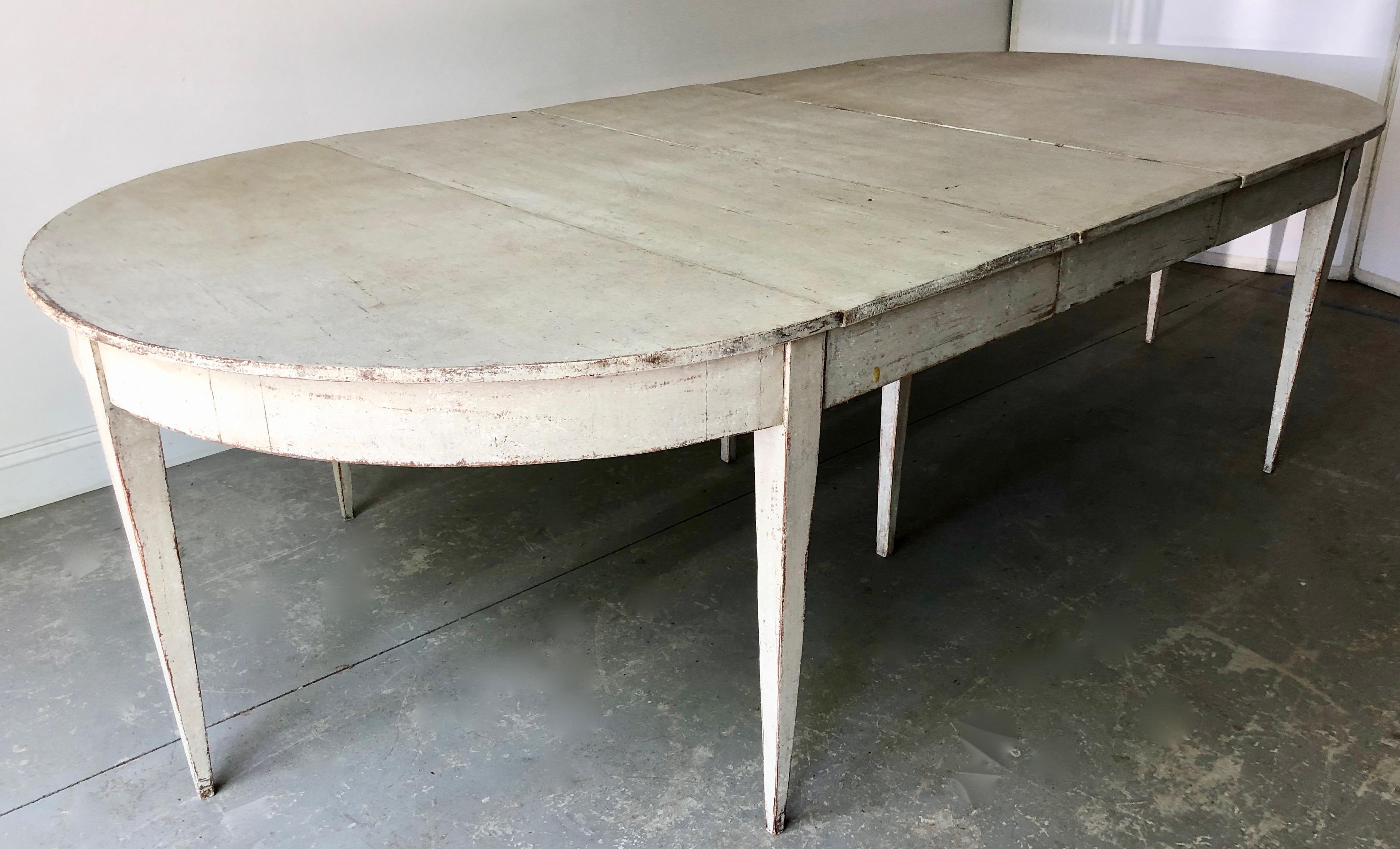 19th century painted Gustavian style extending table with three leaves and tapered legs. Paintwork later. A practical piece that can be used as round table or extended with one, two or three leaves up to 109.50