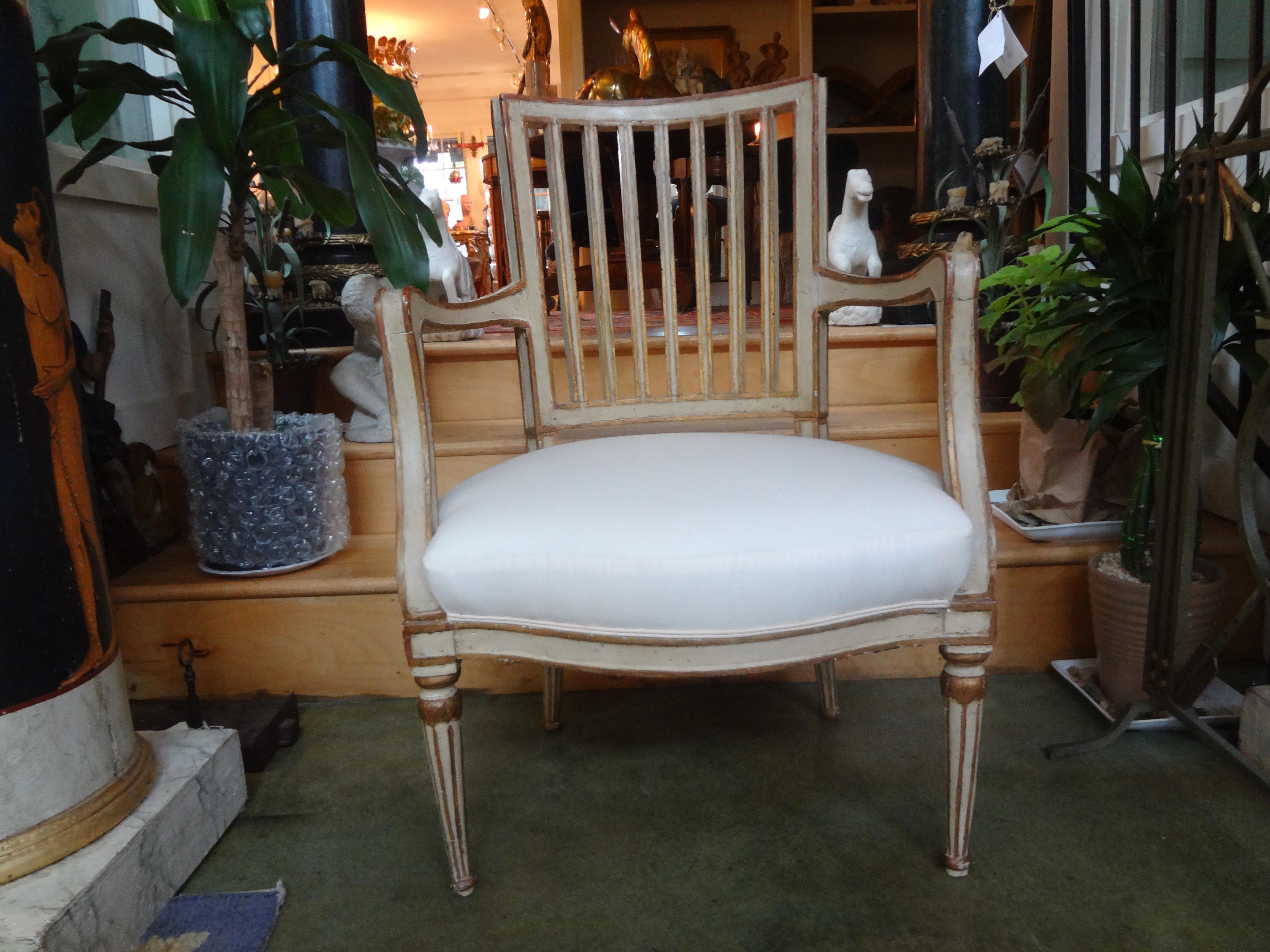 Stunning 19th century Swedish Gustavian style painted and giltwood armchair. This chair is painted a beautiful shade of cream with gilt accents. This versatile chair would be a perfect side chair, accent chair or desk chair.