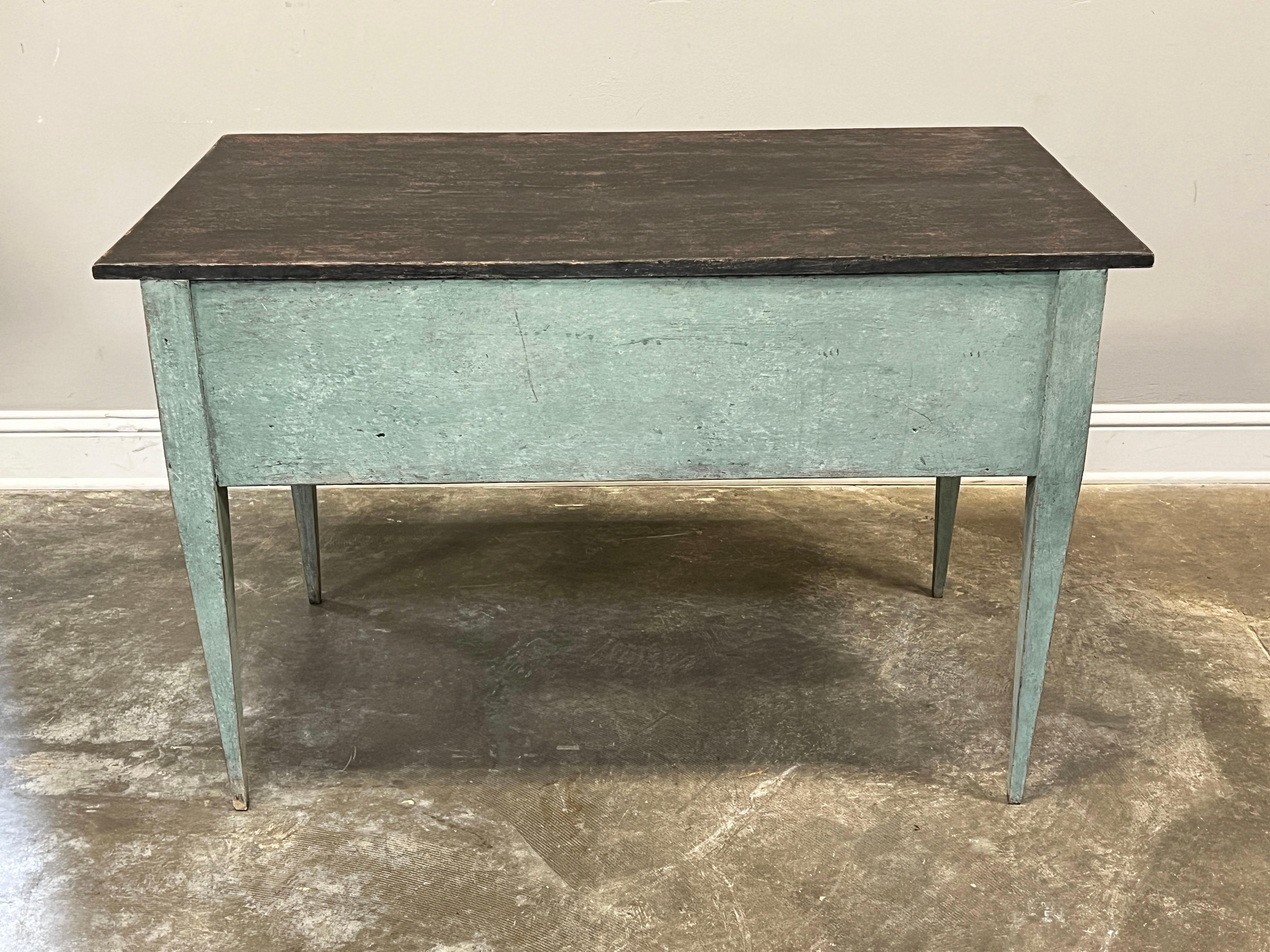 Beautifully painted in a contemporary turquoise, this Swedish Gustavian style desk is handmade with mortise joints and dovetailed drawers.

On each drawer there is horizontal fluting with brass hardware and classic tapered legs.

Leg opening 17