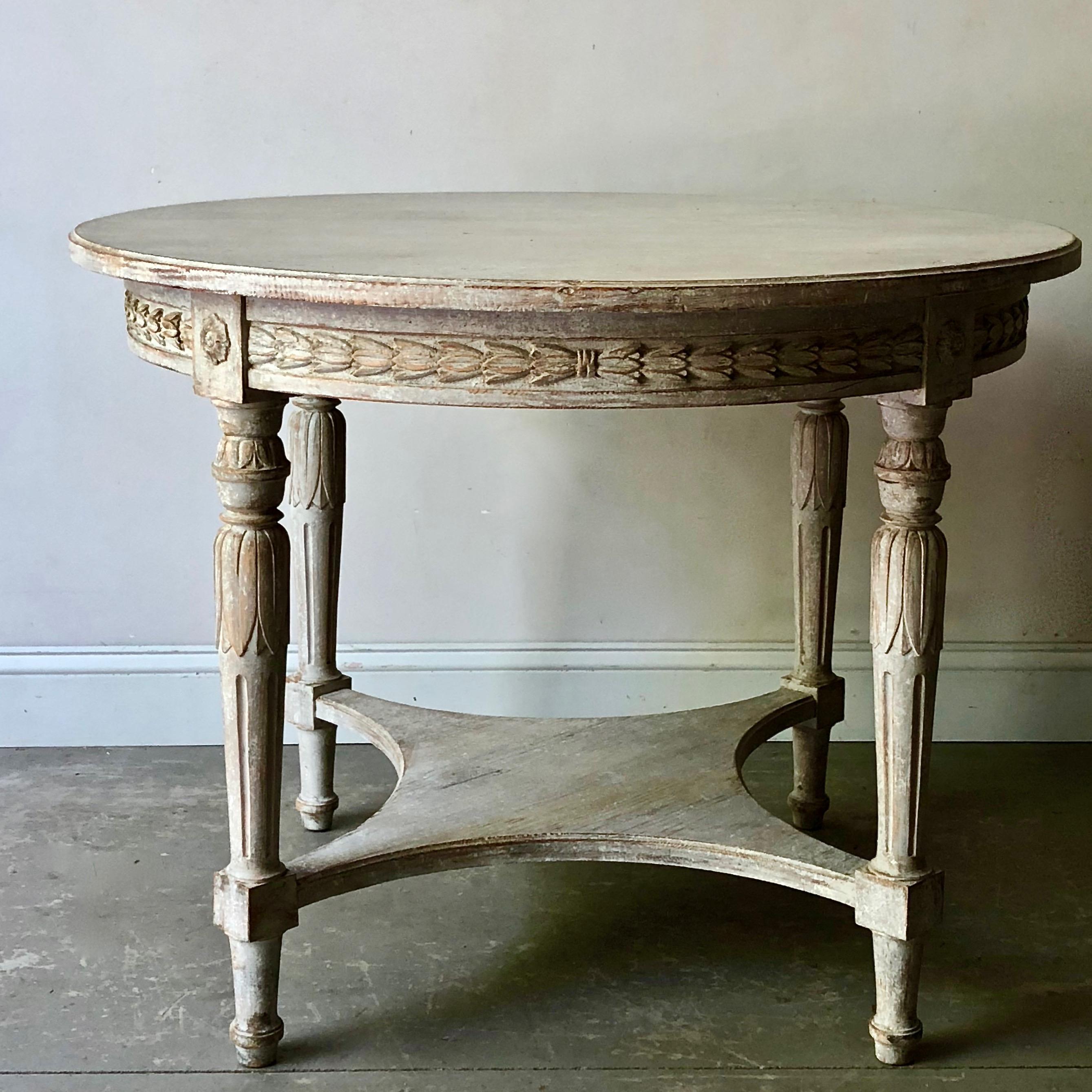 Swedish Gustavian style round centre table with richly carved apron and tapering reeded legs with saltire strecher.
Stockholm, Sweden, circa 1880.

 