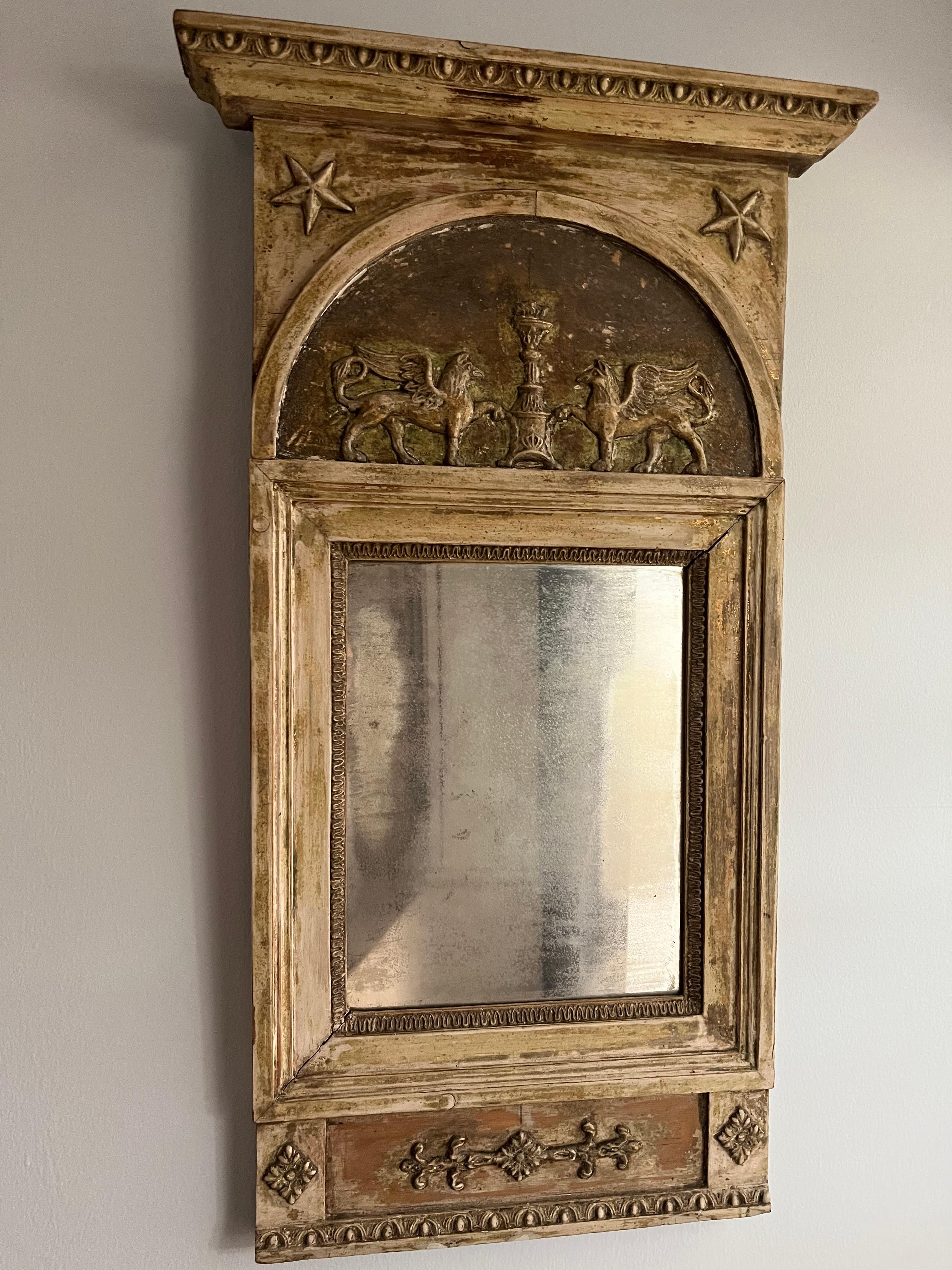 Miroir suédois de la fin de la période gustavienne, dont la surface est grattée et qui présente des restes de peinture et de dorure d'origine. Des sculptures détaillées ornent la moulure supérieure avec des étoiles dans chaque coin. Deux pégases