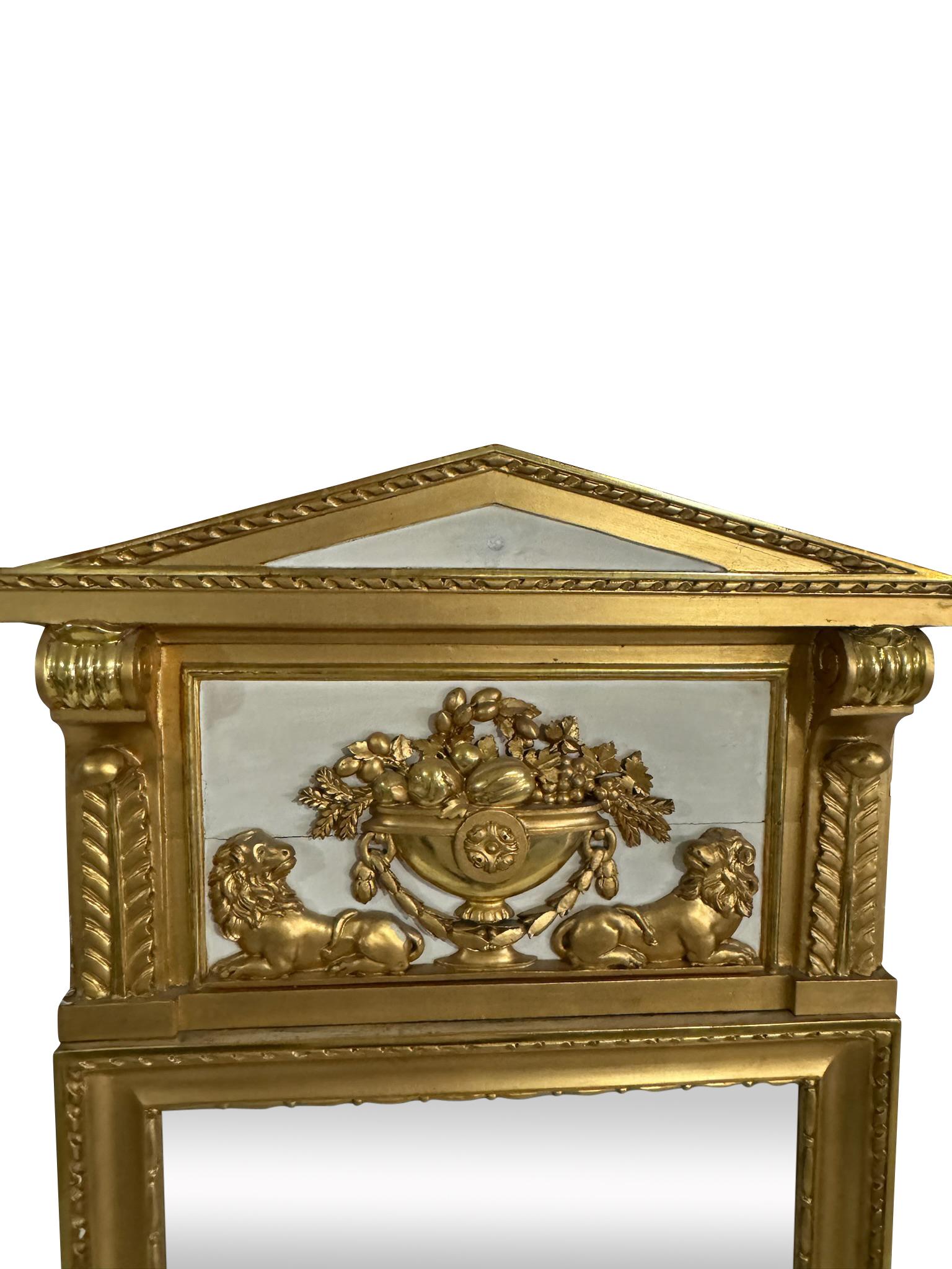  19th century. Giltwood Neoclassical pier mirror with pediment top. Gilt basket of fruit flanked by two lions. The pediment is decoratively supported by two scrolled corbels.  The bottom of the mirror is delicately decorated with rosette, foliate,