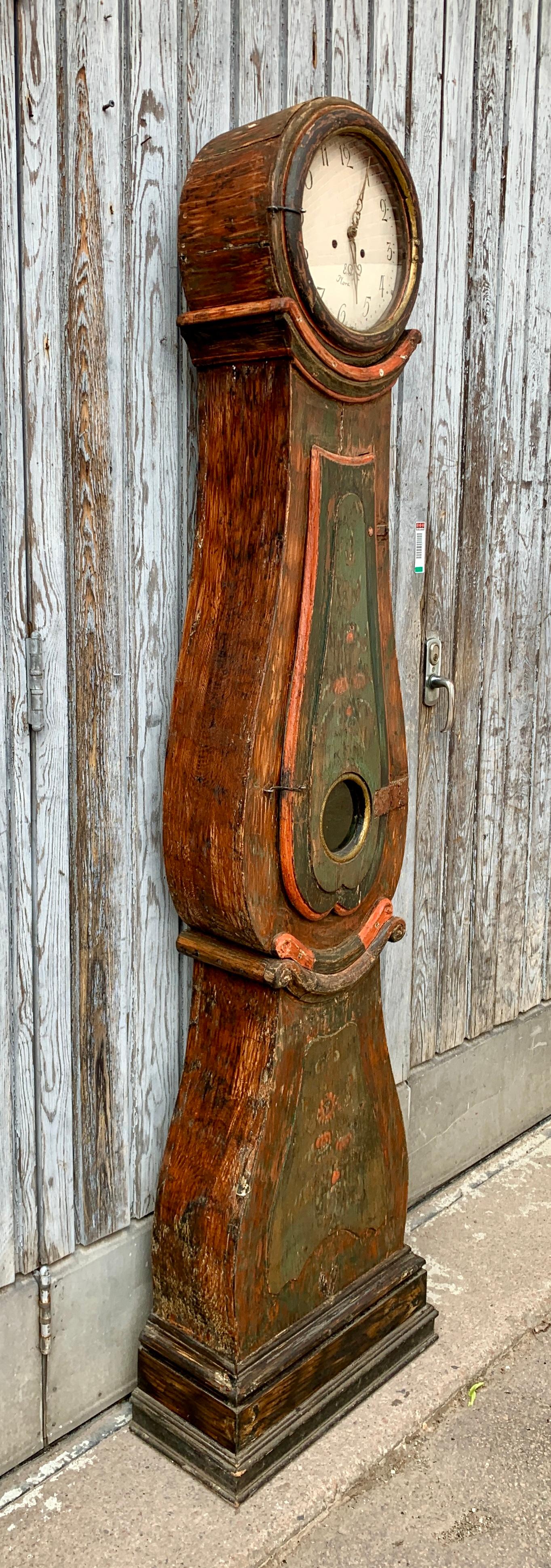 An early 19th Century original painted long case clock or Grandfather clock from Sweden. This Scandinavian folk art clock from the famous (for clock mechanism production) town of Mora in the region of Dalarna in Sweden, is completed with pendulum