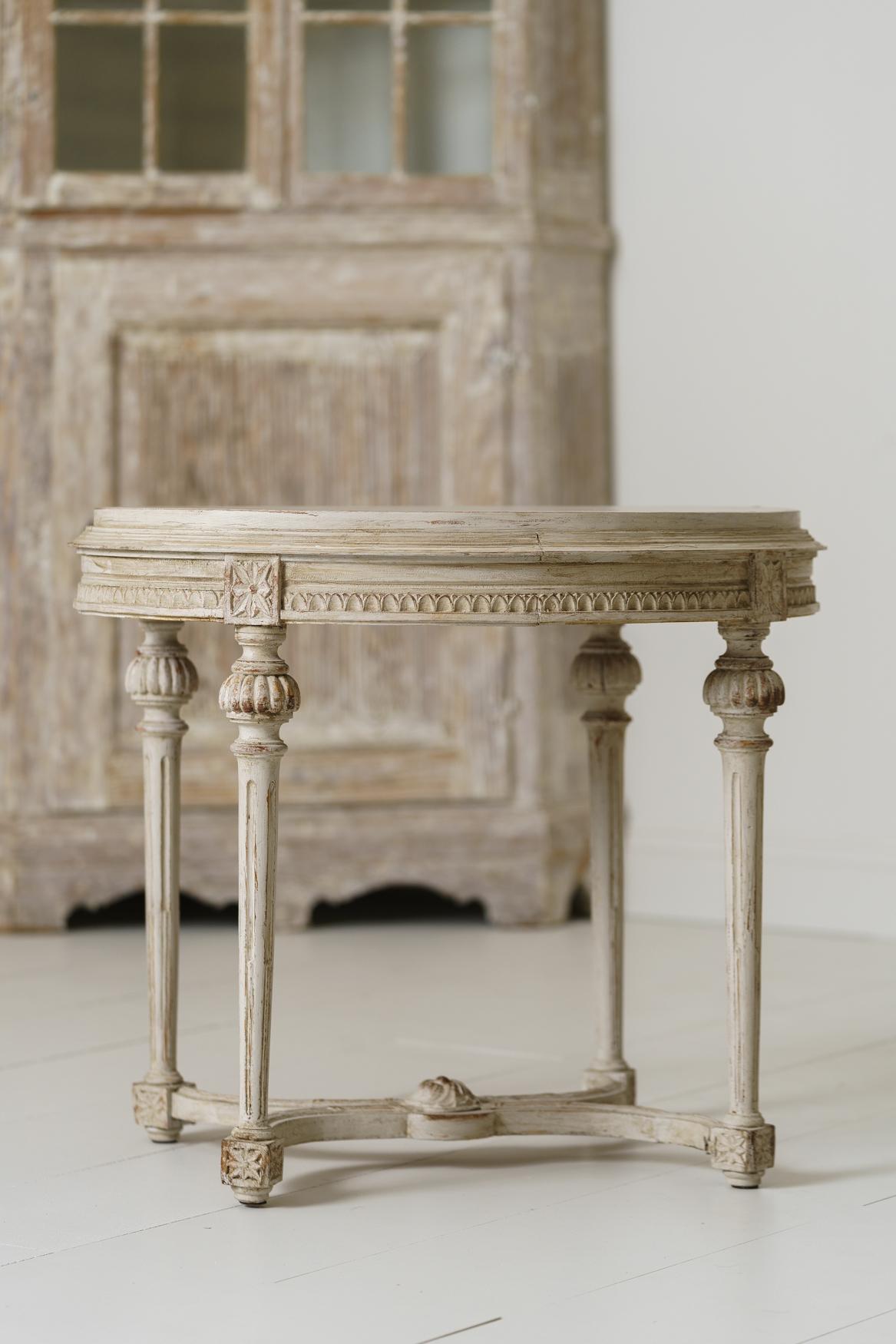 A beautifully carved Swedish late Gustavian period table. The apron features egg and dart detail. There are carved rosettes above fluted, round caps, ending in tapered and fluted legs. A lovely and versatile table.