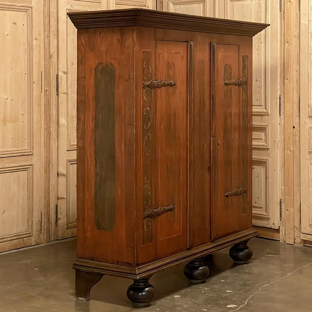 19th Century Swedish Painted Armoire makes an impressive visual statement, while possessing an innate rustic charm thanks to the hand-painted finish and designs on the facade. Hand-forged iron strap hinges and lockworks are original to the piece.