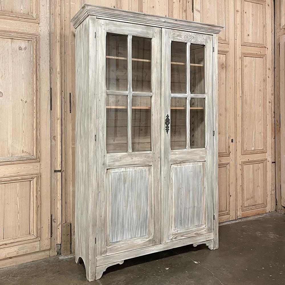 19th Century Swedish Painted Bookcase features a stately, tailored architecture that makes it incredibly versatile in a wide variety of decor styles.  Hand-crafted from old-growth indigenous pine, it features four panes of glass on each door at the