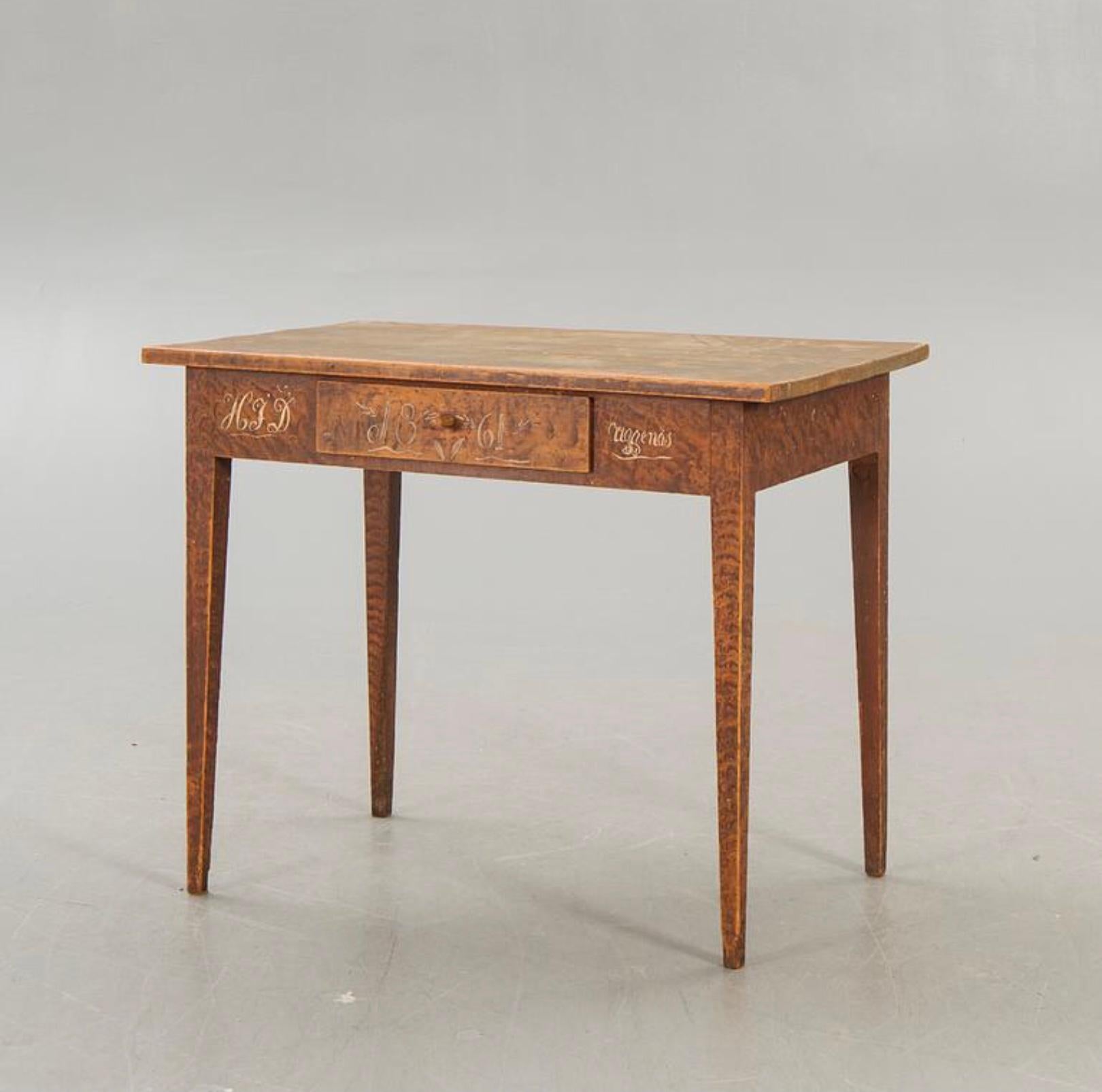 A charming painted swedish side table that has a central drawer with a knob handle which has a sectioned interior.
The top is simple and plain with the main body having the original paint with a scrumbled effect and the front frieze featuring