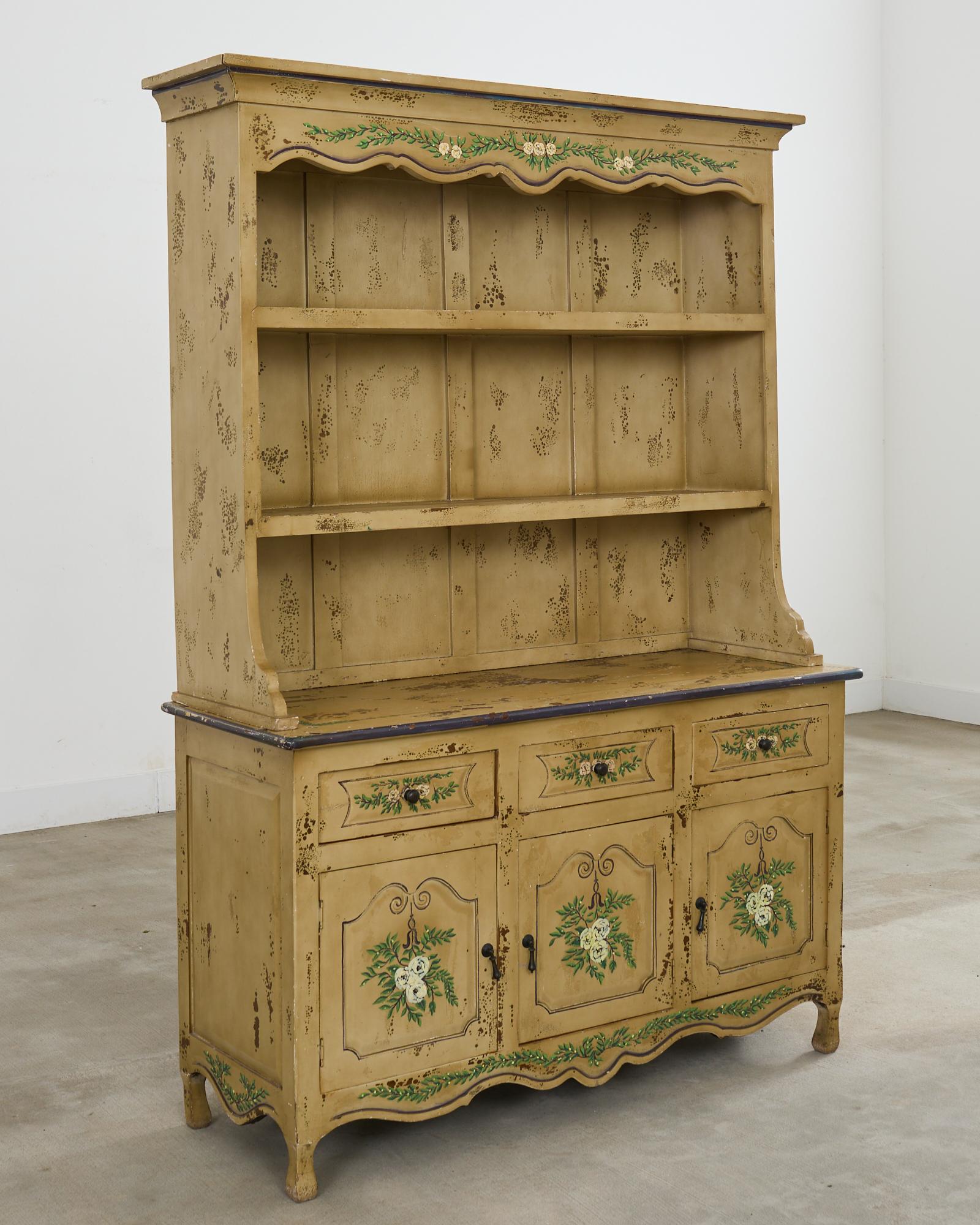 Beautifully weathered late 19th century country Swedish two-part cupboard dresser with a plate rack. The cabinet features a charming painted finish decorated with white floral motifs and foliate. The later painted finish has an intentionally