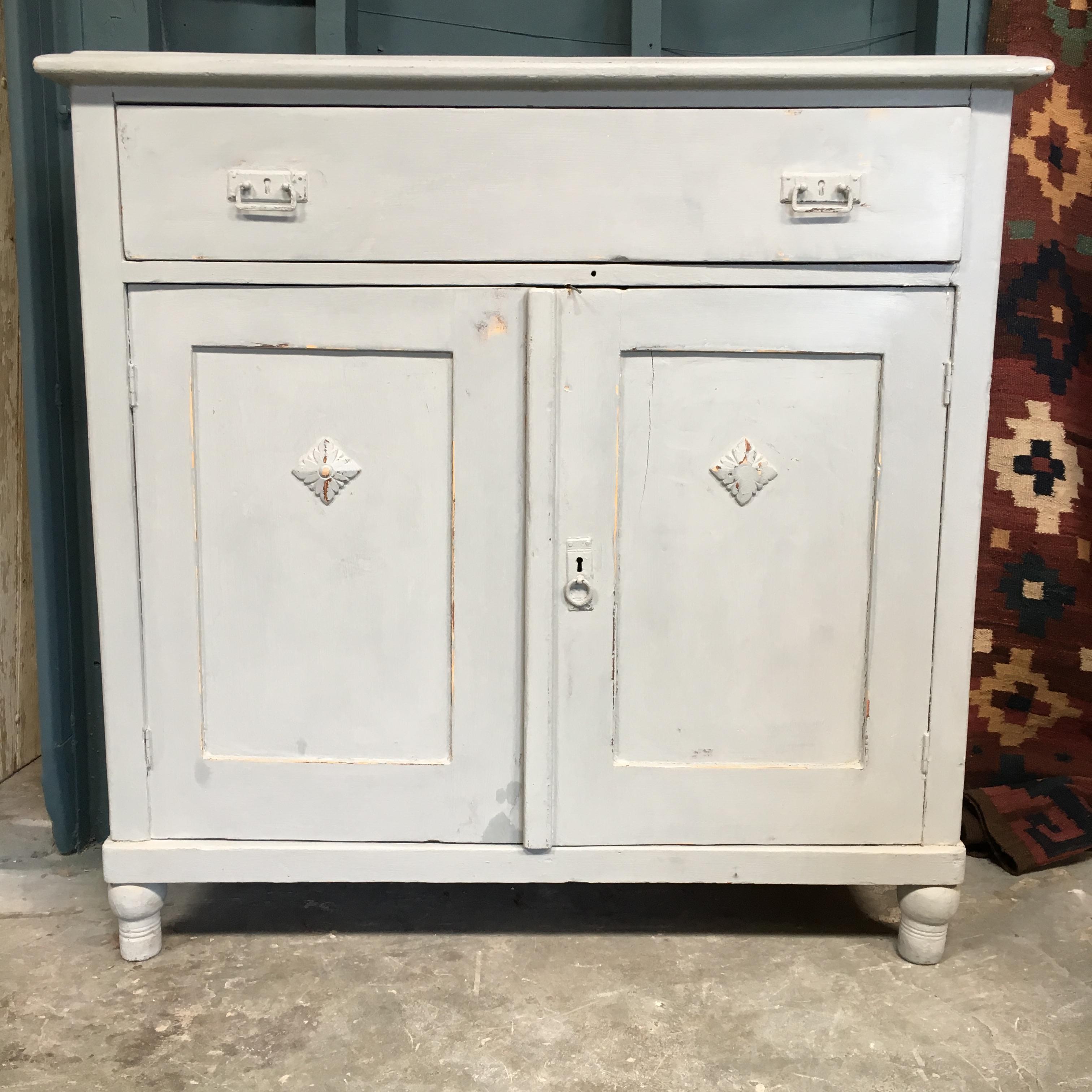 19th century Swedish dresser, circa 1870. 
Two drawers above a double door cupboard which opens to one shelf.
Turned wood legs and distressed white paint.
Key to lock bottom cabinet.

 