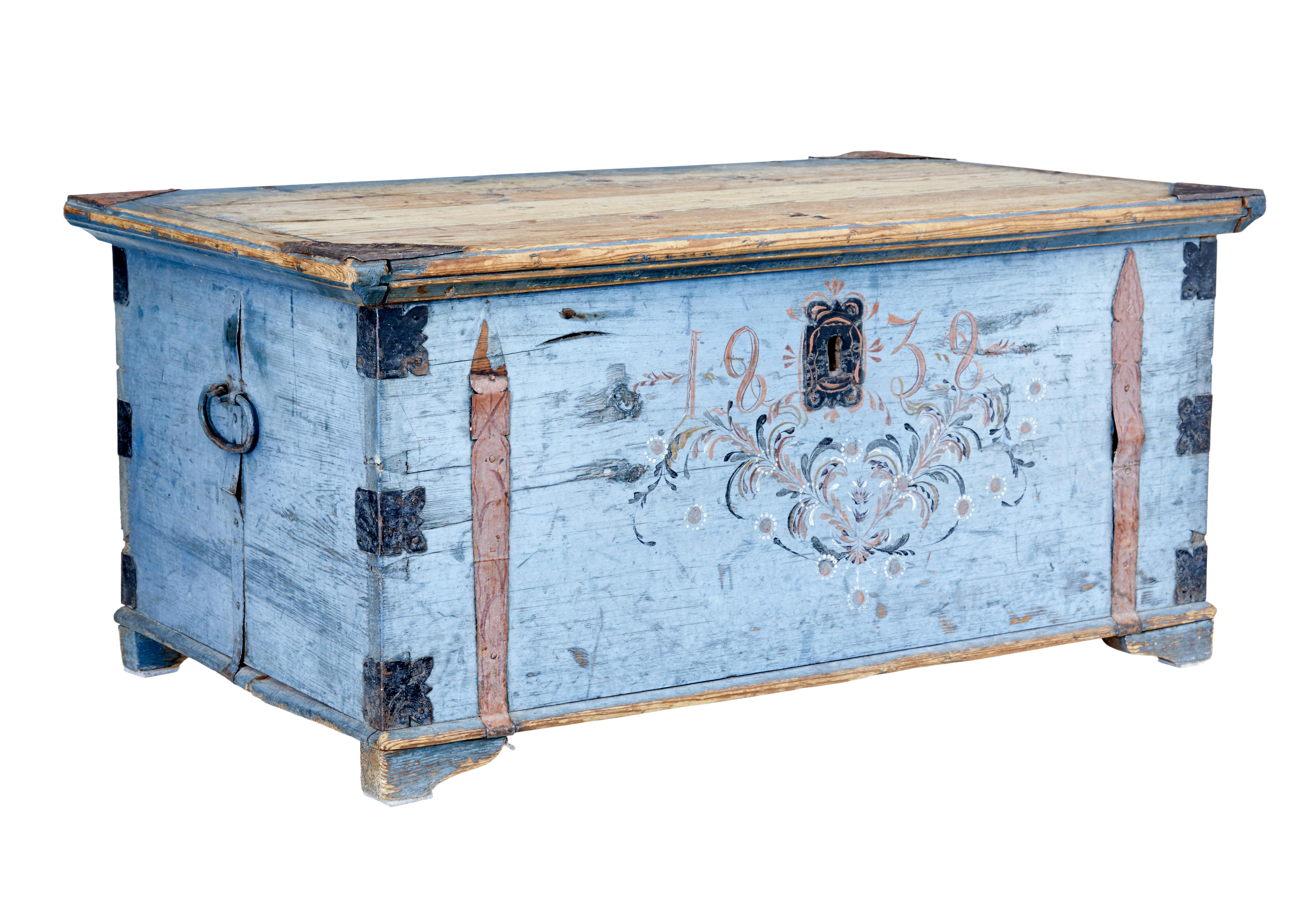 19th century swedish painted pine chest circa 1838.

Decorative painted folk art trunk, baring the hand painted date of 1838. Over time has faded to a desirable muted blue, with contrasting metal strap work. Delicately painted floral swag to the