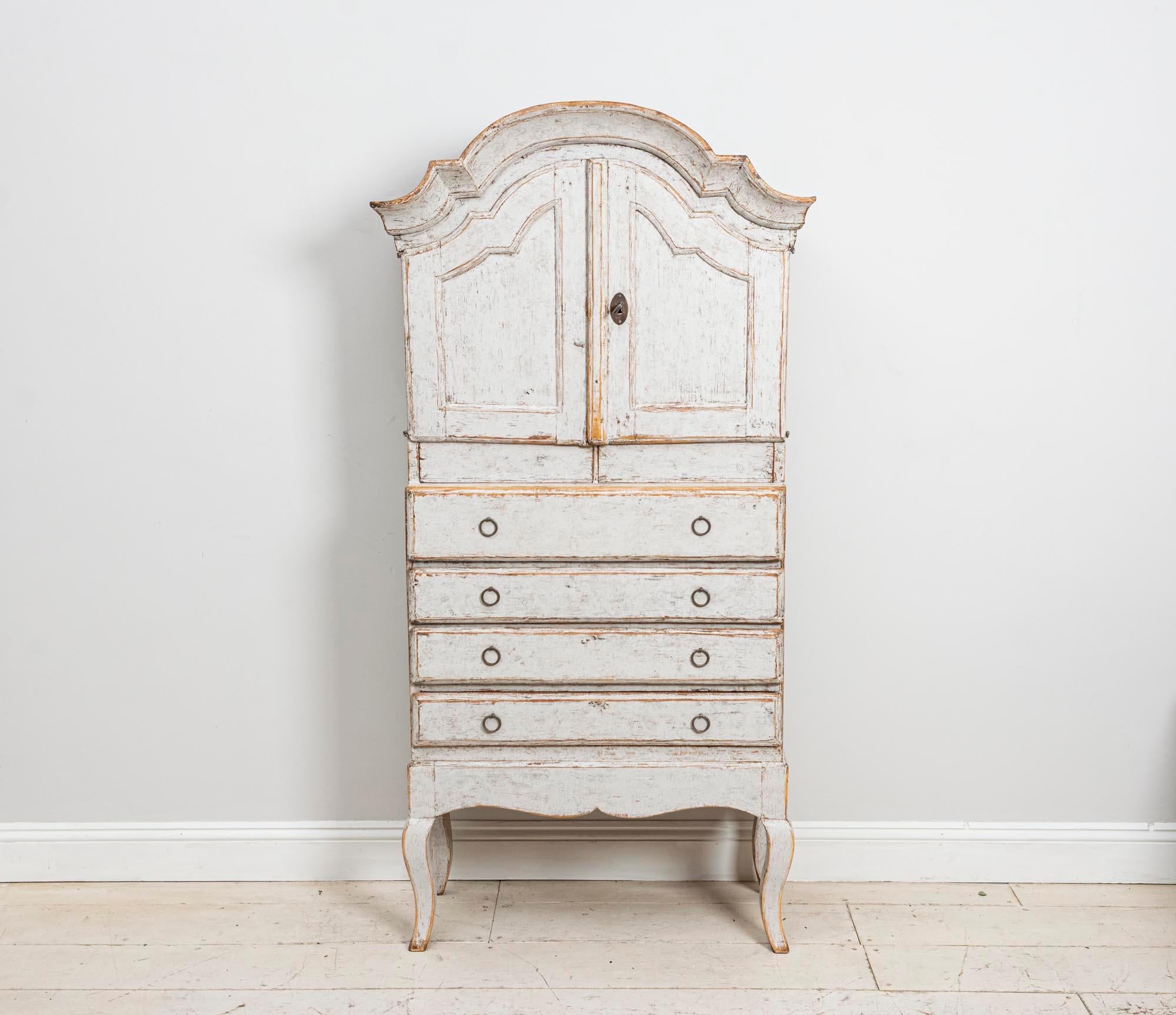 Painted Swedish Rococo cabinet. This slightly quirky circa 19th century piece dates to circa 1820 and is of a more unusual smaller size.

The cabinet is in one piece and does not come apart. The interior has been hand-scraped to reveal the