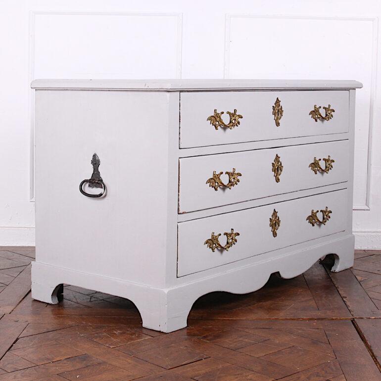 A 19th century painted Swedish three-drawer chest, the drawers with ornate gilt pulls and escutcheons, the sides with original wrought-iron handles. The chest is raised on bracket feet united by a shaped serpentine apron.