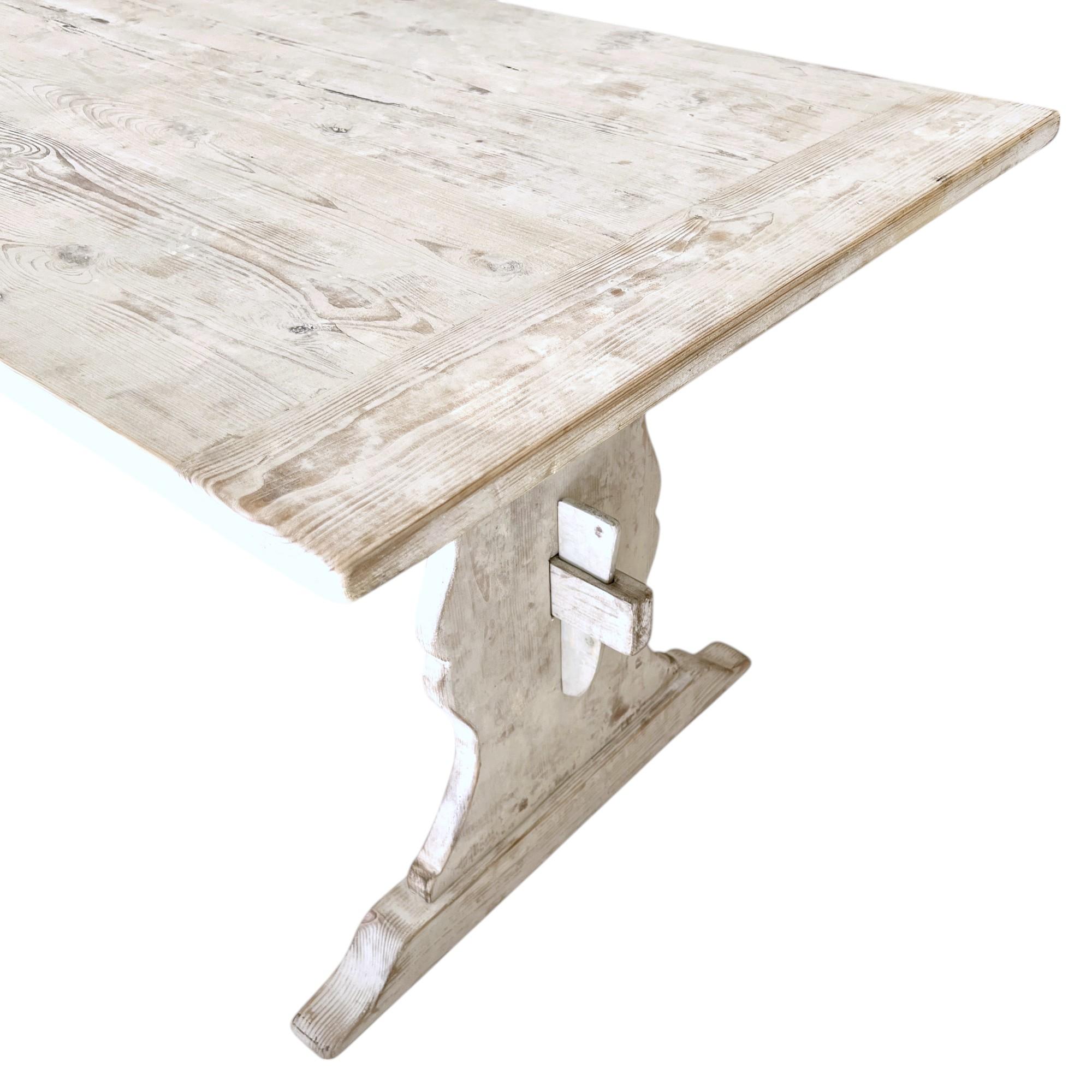 Une table de ferme suédoise peinte en blanc du XIXe siècle incarne l'élégance rustique et l'aspect pratique du design scandinave. Cette table présente une construction robuste et usée par le temps, avec des lignes simples et épurées qui soulignent