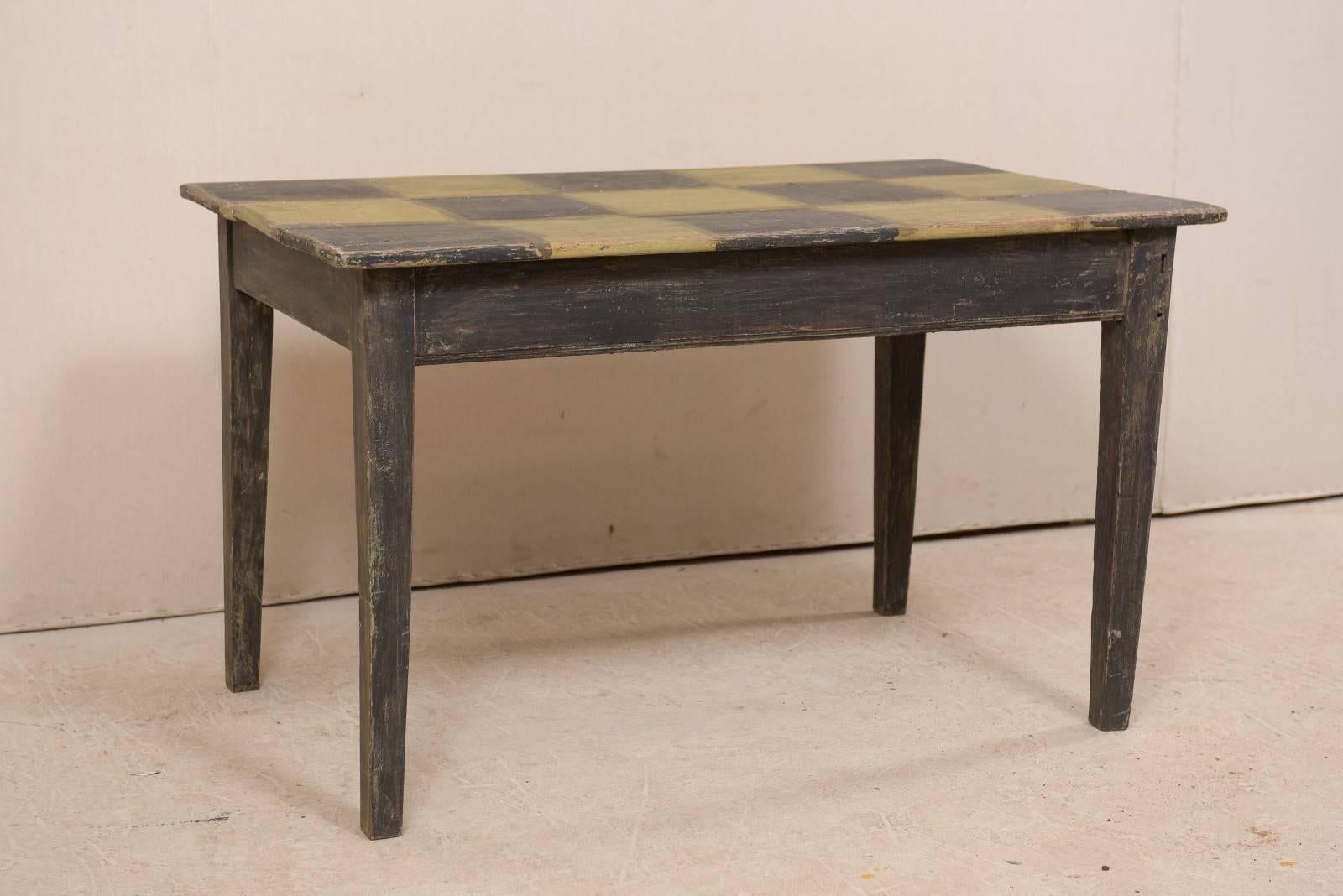 A Swedish 19th century painted checker top table. This fun antique table from Sweden features clean, simple lines, which have been contrasted nicely with it's whimsically painted checker top. This table has a rectangular-shaped top with plain apron