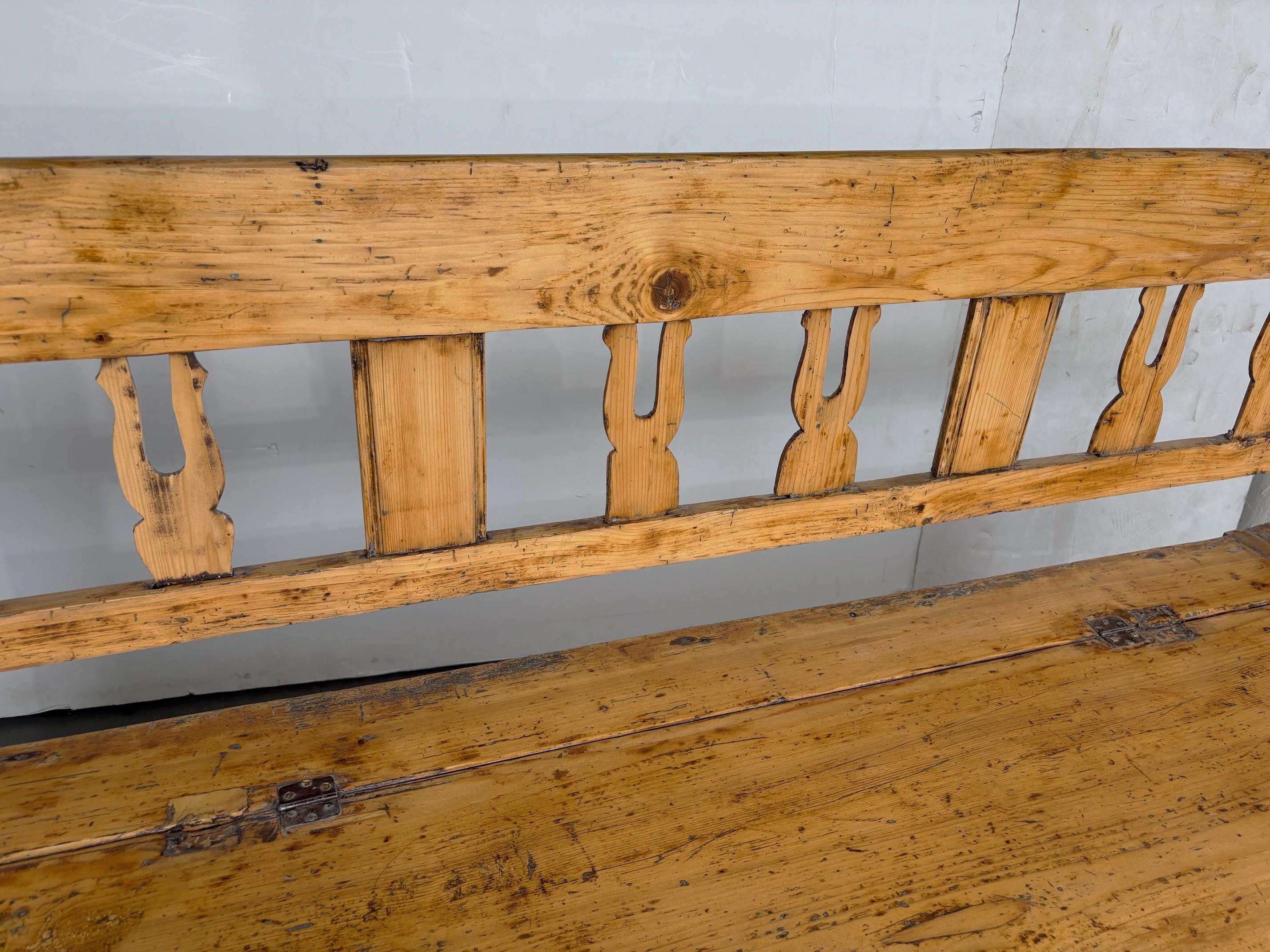 Un ouvrage du 19e siècle  banc rustique en pin avec panneaux au dos et rangement.