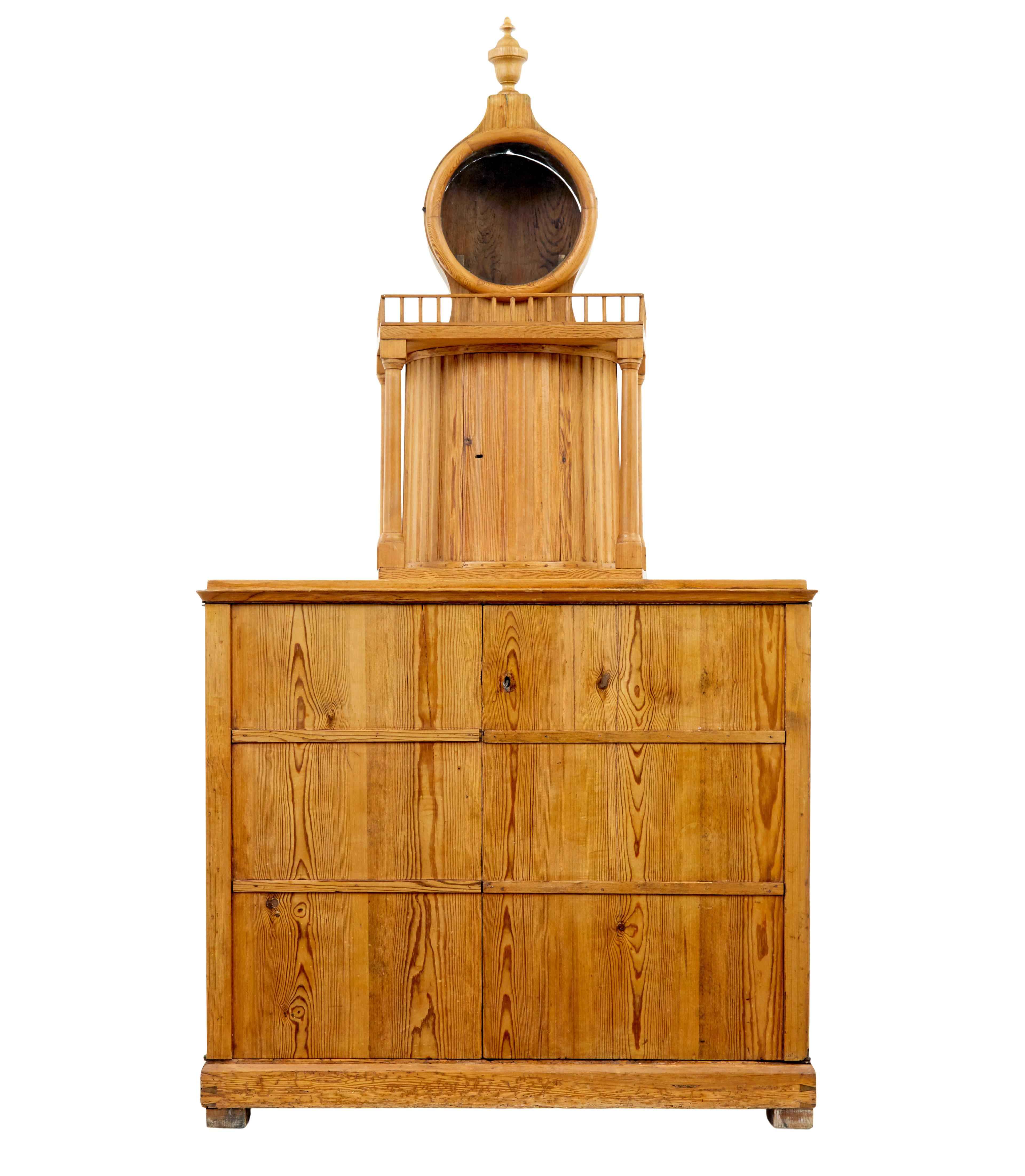 19th century Swedish pine kitchen cupboard circa 1880.

Rare Swedish pine cabinet featuring a clock tower on the top surface.   Clock face mount with removable hood, the chains and weights and pendulum would hang down the central enclosed channel.
