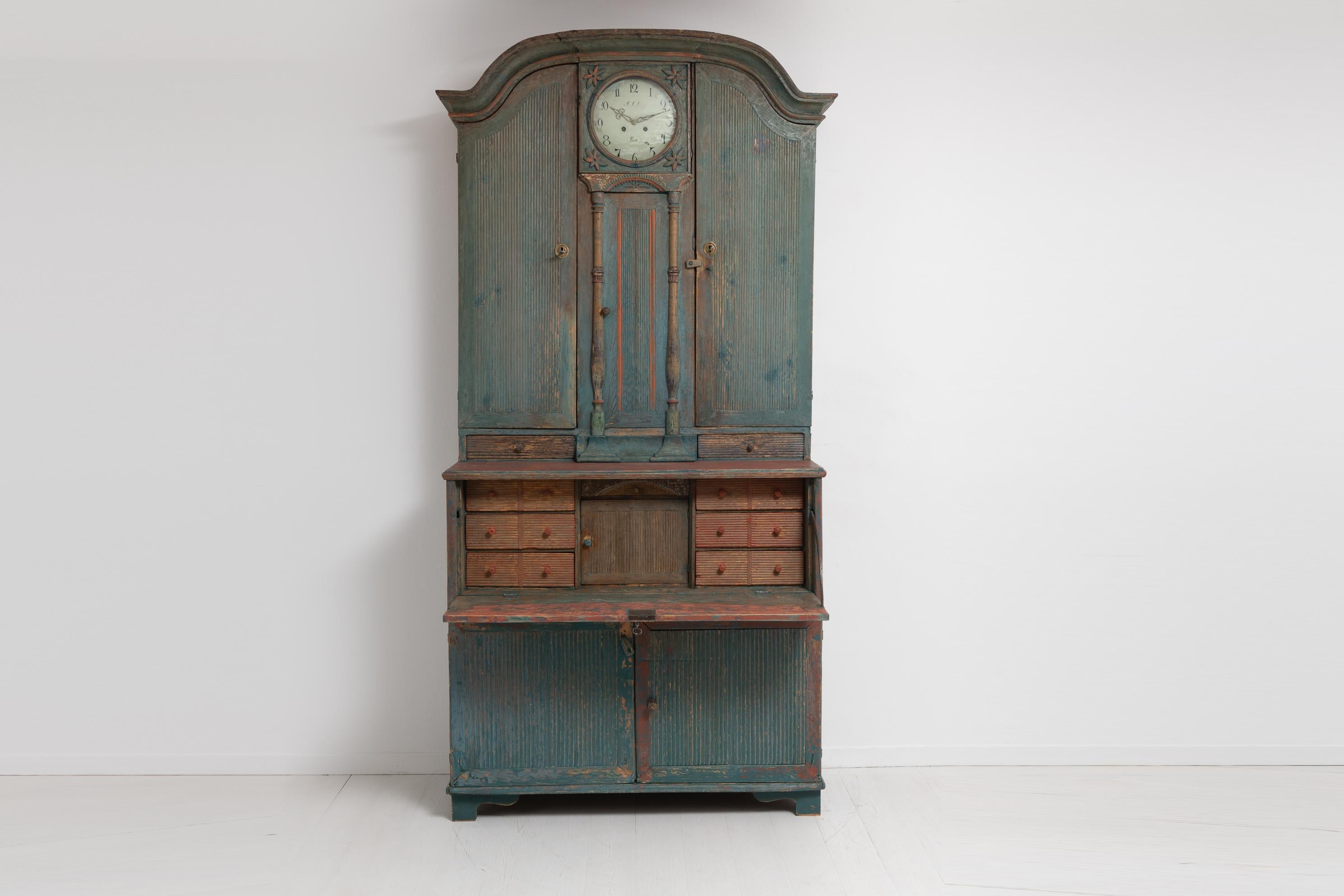 Clock bureau cabinet from the transitional period between rococo and gustavian, around 1810. The clock cabinet is from Northern Sweden and dry scraped by hand to old historic paint. The cabinet combines multiple furnitures by having both the writing