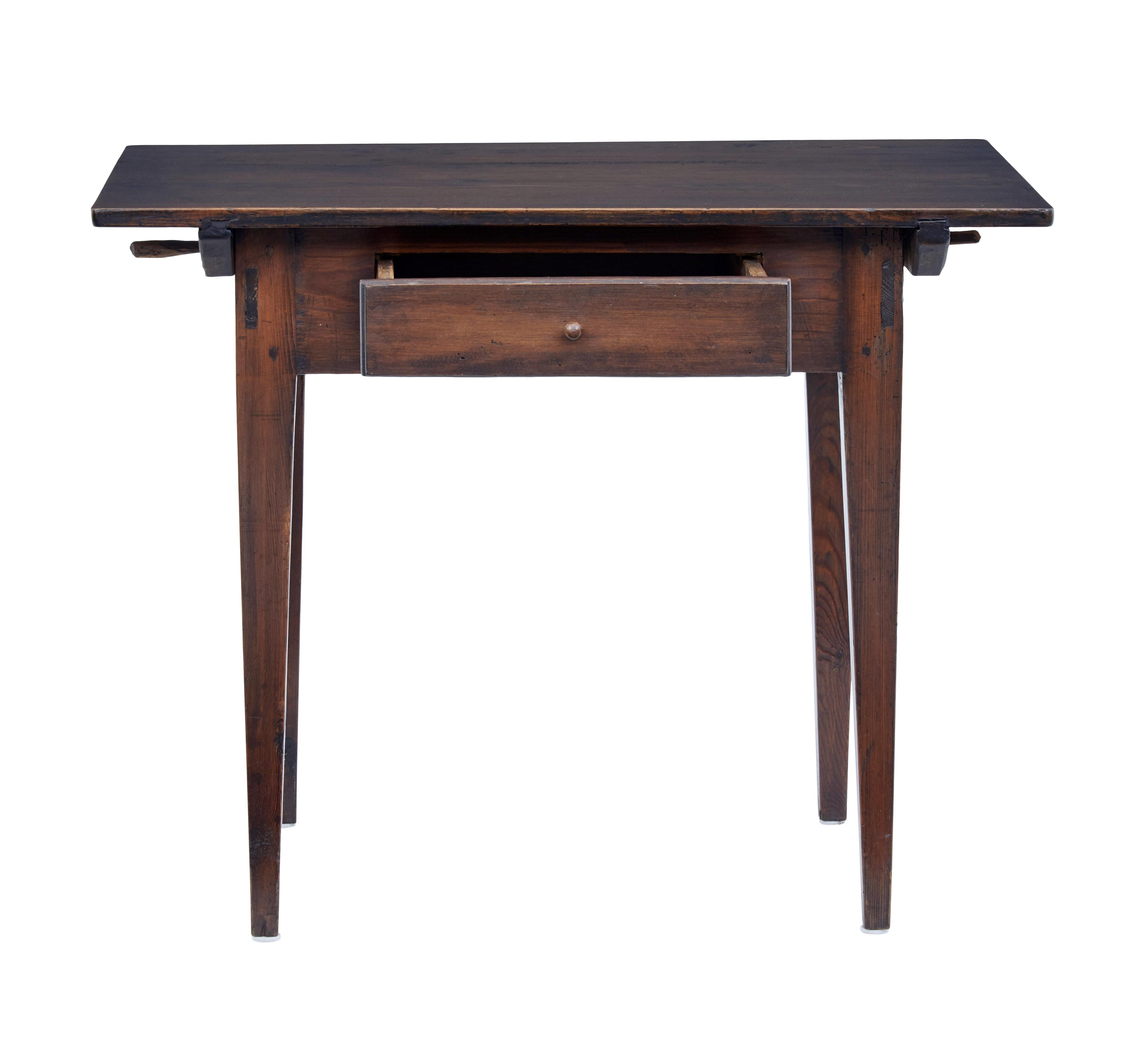 Rustic Swedish pine side table, circa 1880.

Dark stained pine table which has multiple uses such as an occasional desk or hall table. Top surface held in place by pegs. Single drawer to the front, standing on tapered legs.

Expected surface