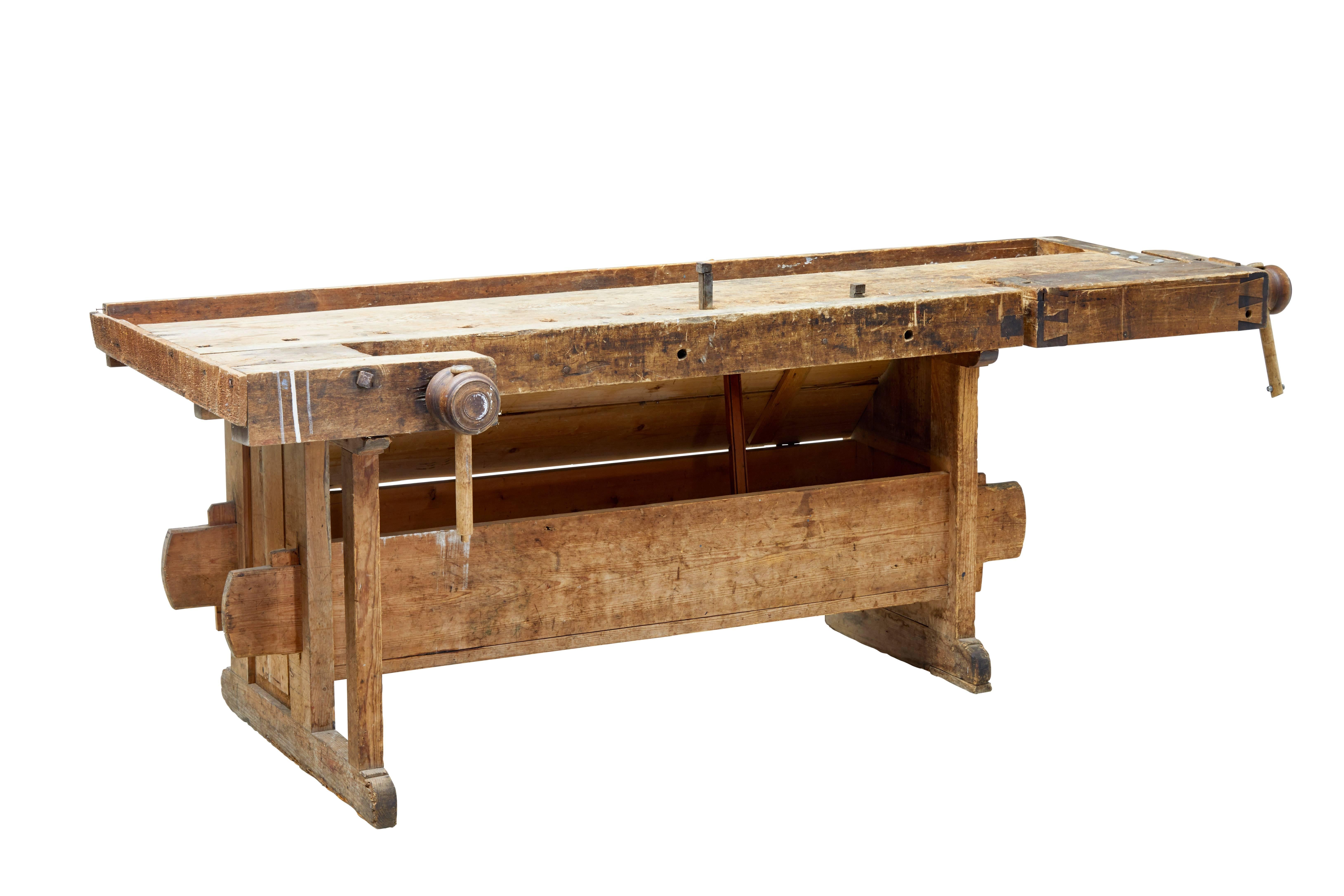 Here we offer a fine 19th century Swedish pine work bench, circa 1880.

Working double clamp on one end, and a threaded clamp to the front.

Obvious signs of use, but fully functional. Standing on trestle legs united by stretchers and held in