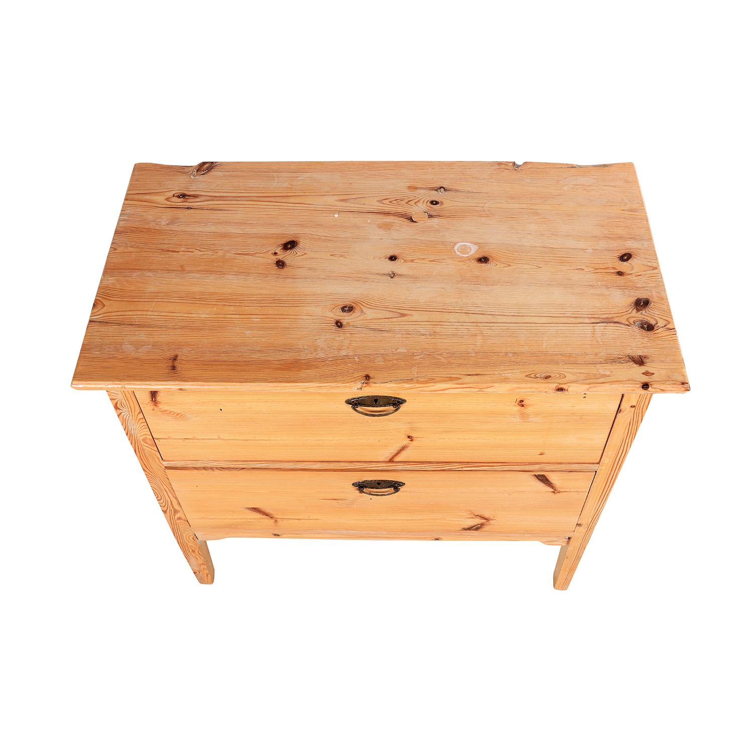 A late 19th Century, antique Swedish bed side table made of hand crafted Pinewood, in good condition. The single Scandinavian nightstand is composed with two drawers, standing on four straight wooden legs, consisting its original brass hardware and
