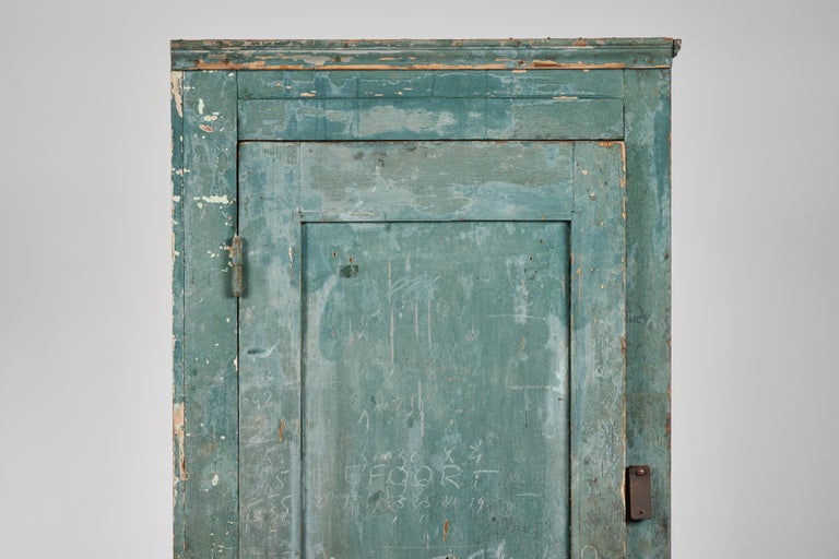 Tall narrow 19th century Swedish primitive cabinet with original blue-green paint, hardware and markings. Back panel missing a section at the lower portion as shown.