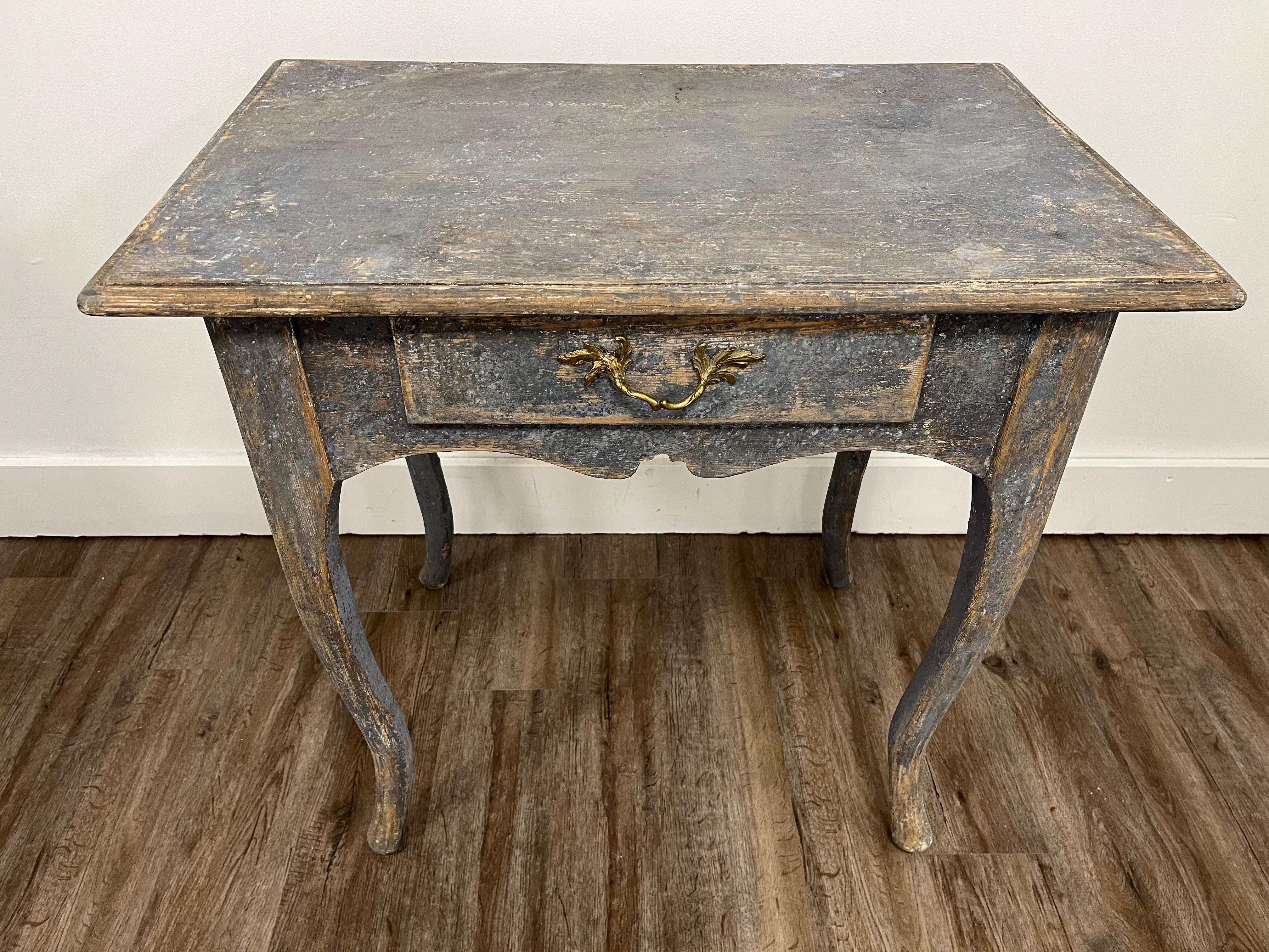 A provincial Swedish Rococo style console table with single drawer. Brass hardware is period but not original to this piece. Wide contoured top sits on a notched skirt and cabriolet legs. Repainted in blue with a patina effect..