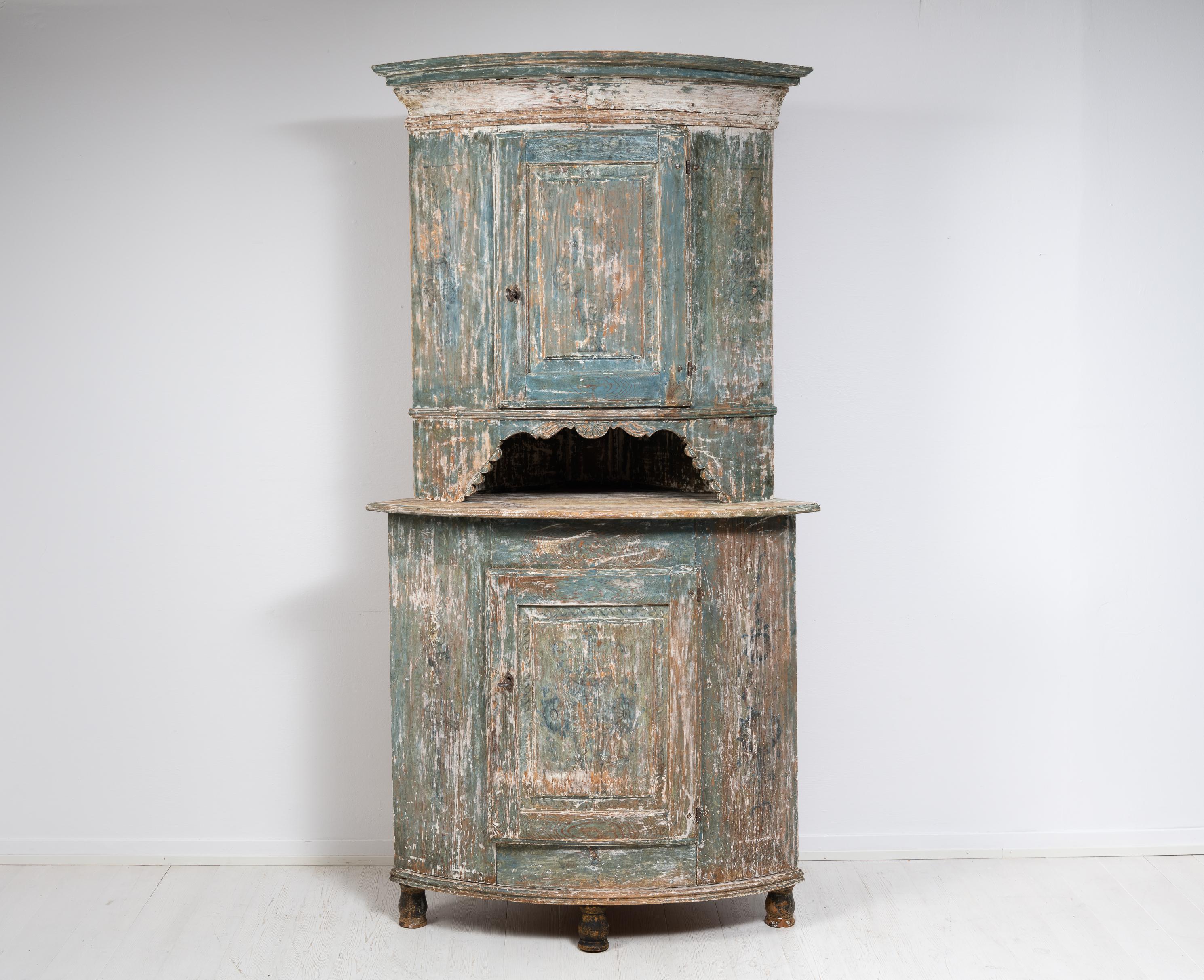 Swedish country house corner cabinet from northern Sweden. The cabinet is a Swedish country home furniture from the first half of the 19th century, circa 1820 to 1840. Made in painted pine with traces of the original paint. The cabinet has distinct