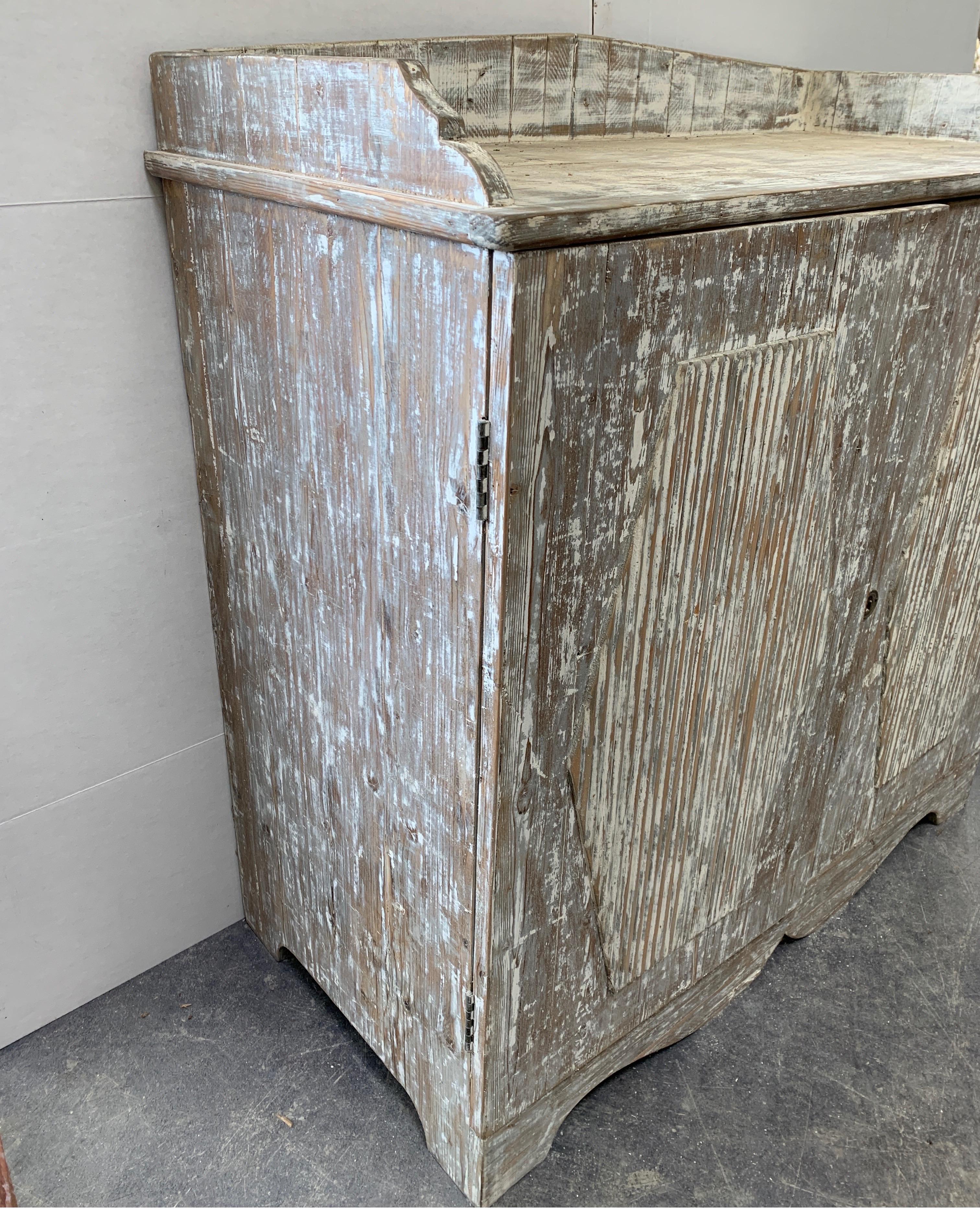 This is a very well made two-door buffet from Sweden that has a small drawer inside and two shelves for storage. It’s been scraped back to original white and features the reeded carved front that’s typical of Gustavian era. Measures: 41 W x 20 D x