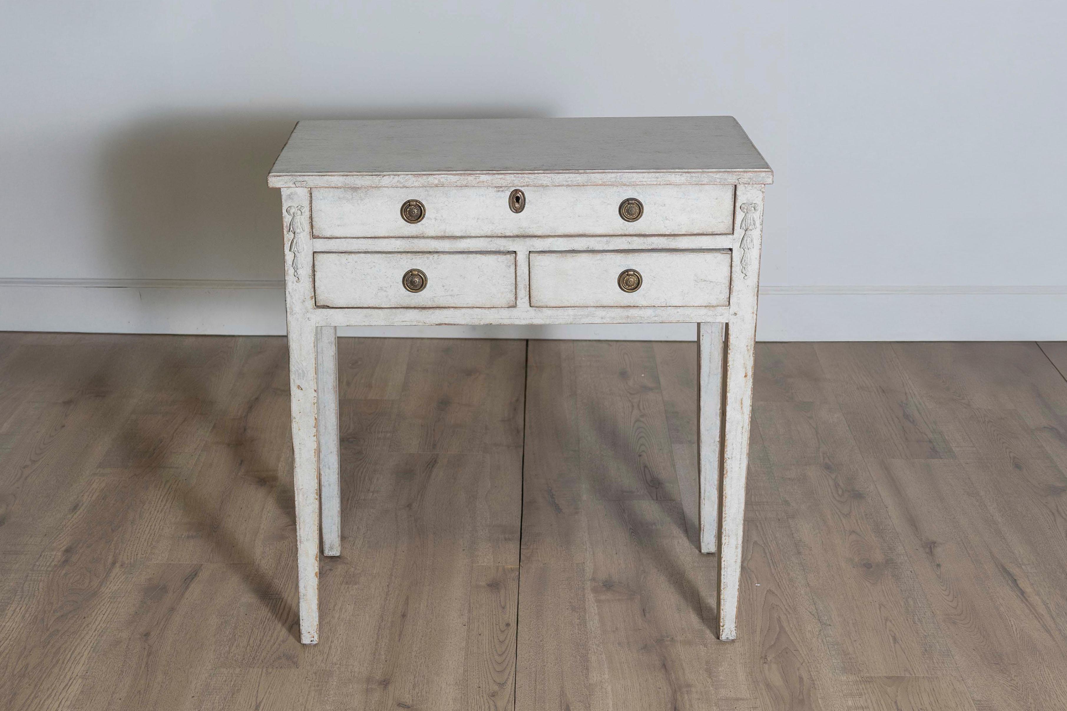 Cette table d'appoint suédoise du XIXe siècle, vers 1850, est un charmant exemple de design d'inspiration gustavienne, alliant simplicité et détails élégants. Fabriquée en pin, la table présente une finition peinte dans des tons doux et neutres,