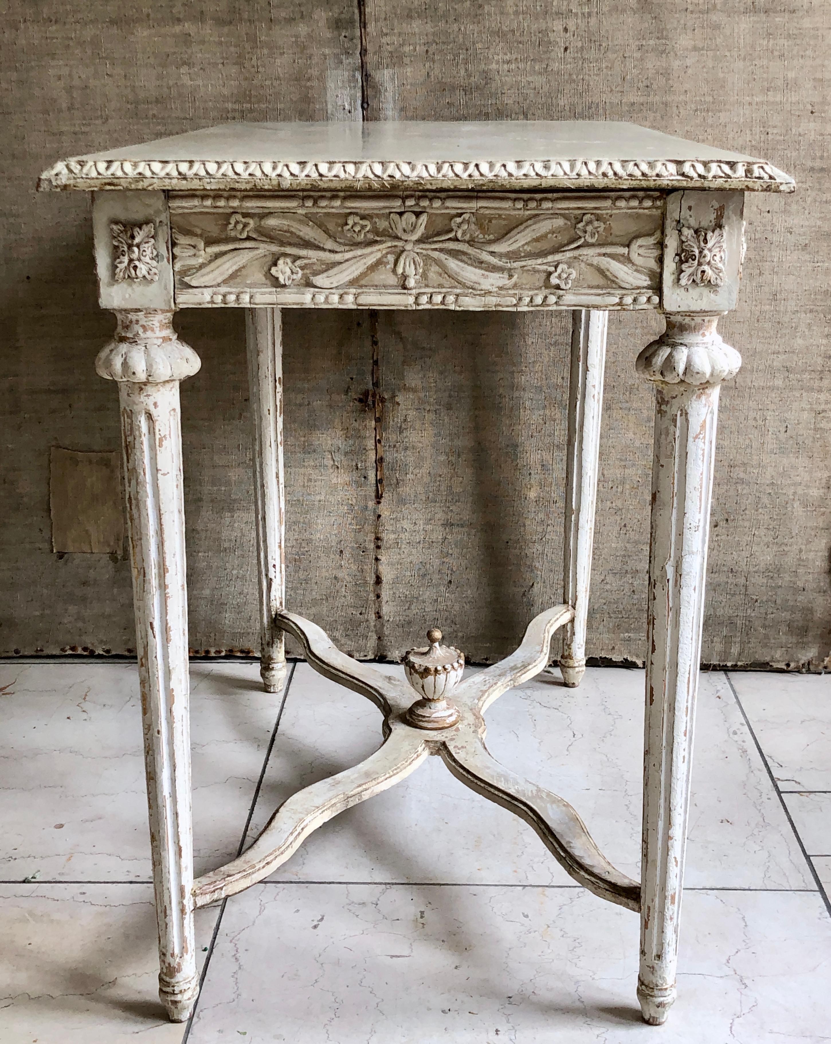 19th century small side table with exceptional detail. Lamb’s tongue molding around the marbelized wooden top, floral motifs around the apron on all four sides and applied florets on the corner blocks above turned, reeded and tapered legs with