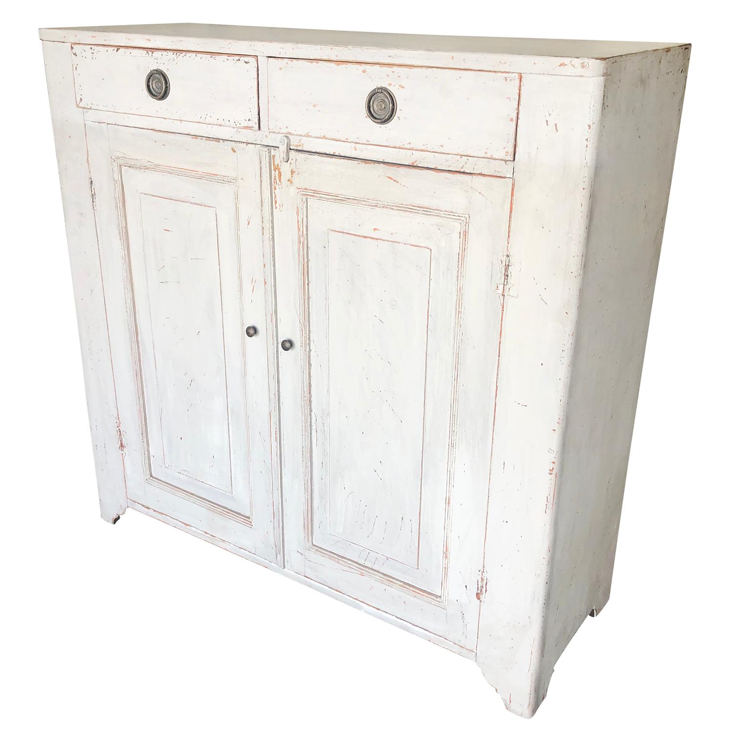 An antique Swedish Gustavian sideboard made of hand carved Pinewood and chrome, comprised of two doors with raised panels. Refreshed white-grey finish, detailed in the neoclassical Greek style with their original hardware, in good condition. Wear