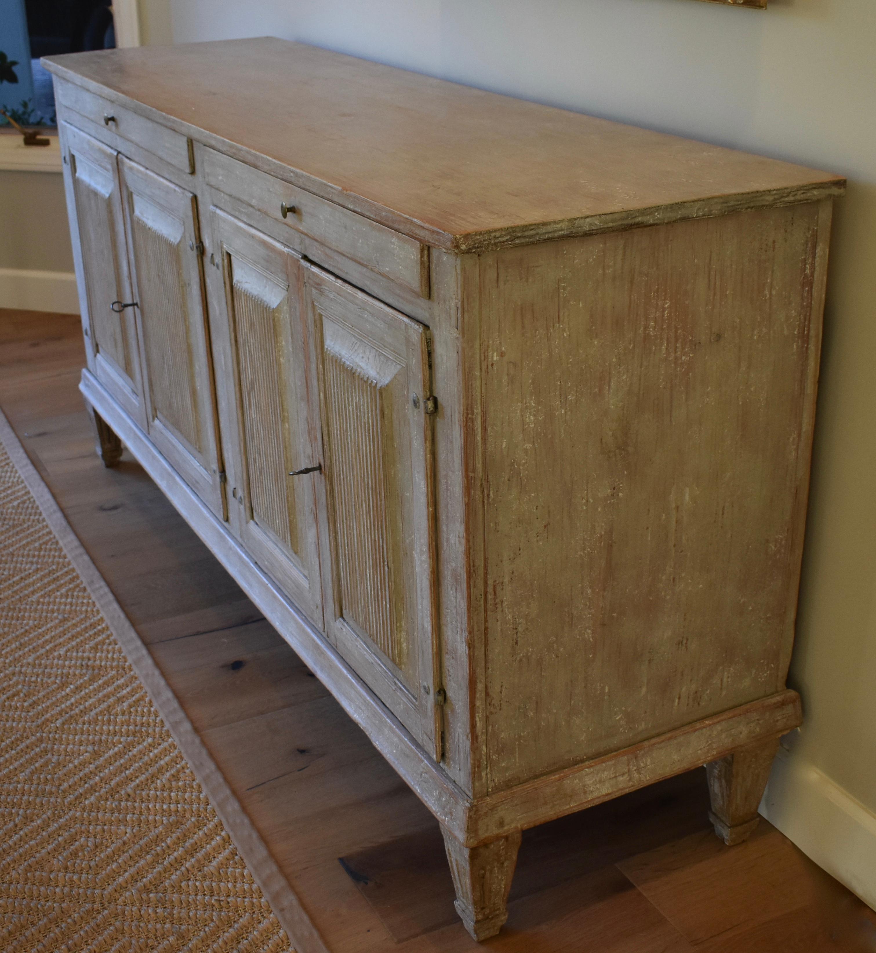 Beautiful 19th century Swedish sideboard or server with reeded paneled doors and tapered legs. Cutlery drawers and cupboards with shelves for great storage. Lovely Swedish white/grey color.