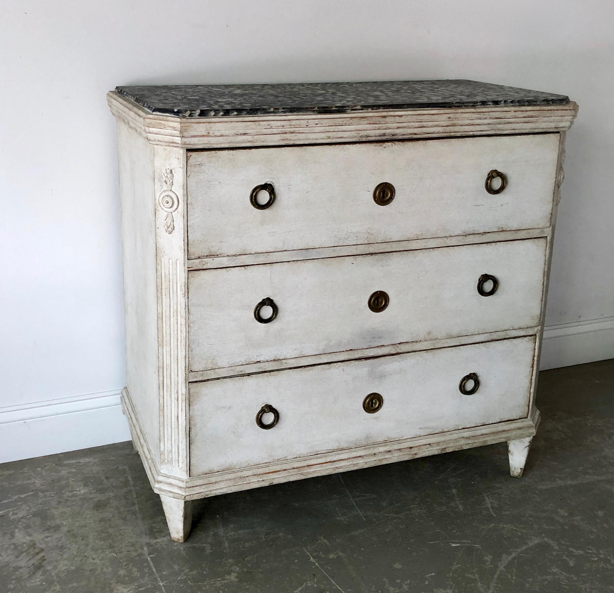 Charming 19th century Swedish three drawers chest with floral applicants on each reeded corner posts under very interesting marblesized wood shaped top and tapering square legs 
Sweden, circa 1880.
 More than ever, we selected the best, the