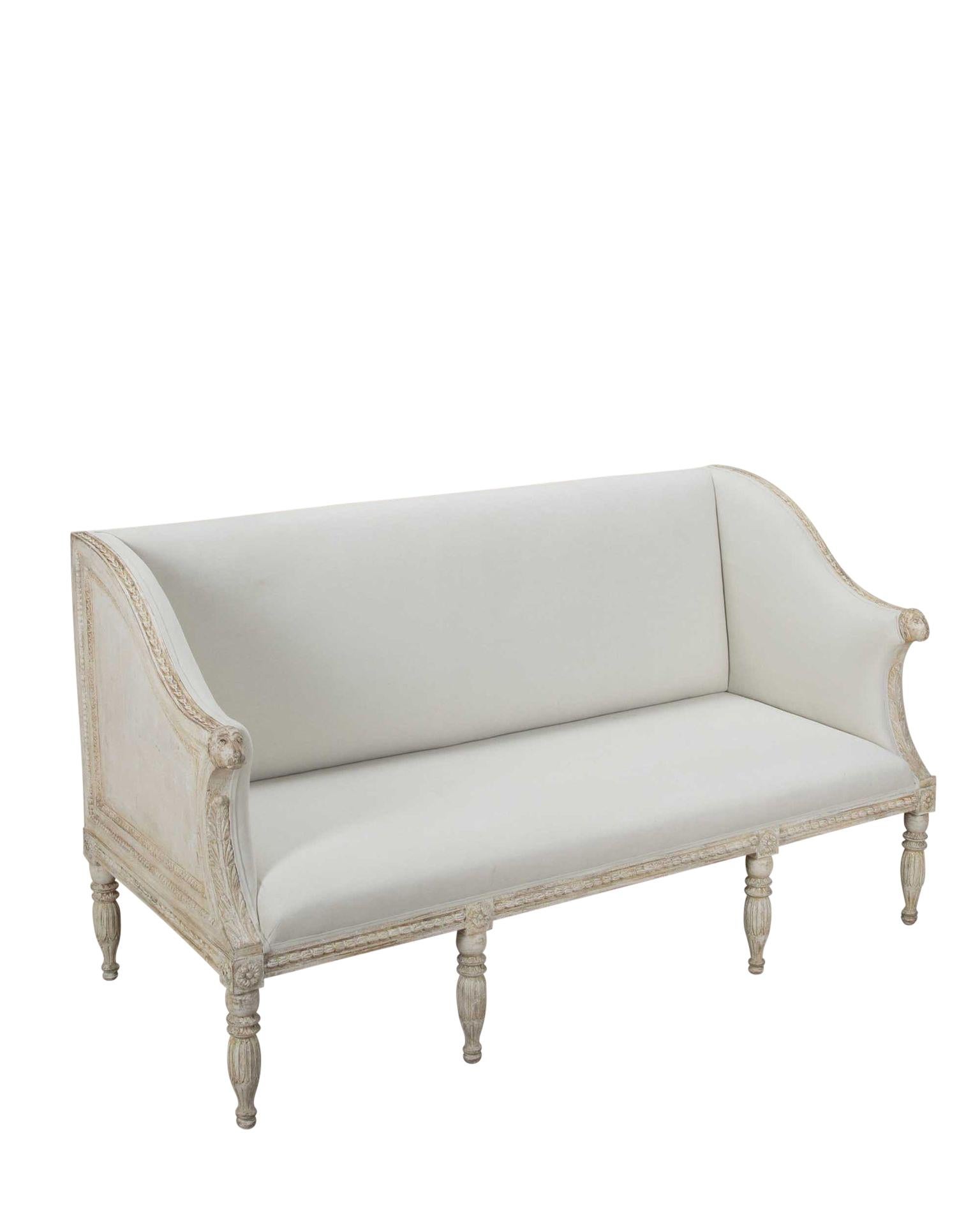 Canapé suédois de la fin du 19e siècle, à la manière d'Ephraim Ståhl. 
Superbe sculpture décorative autour du canapé, se terminant par des têtes de lions en bois sculpté. 
Rembourré en lin. Circa 1880.