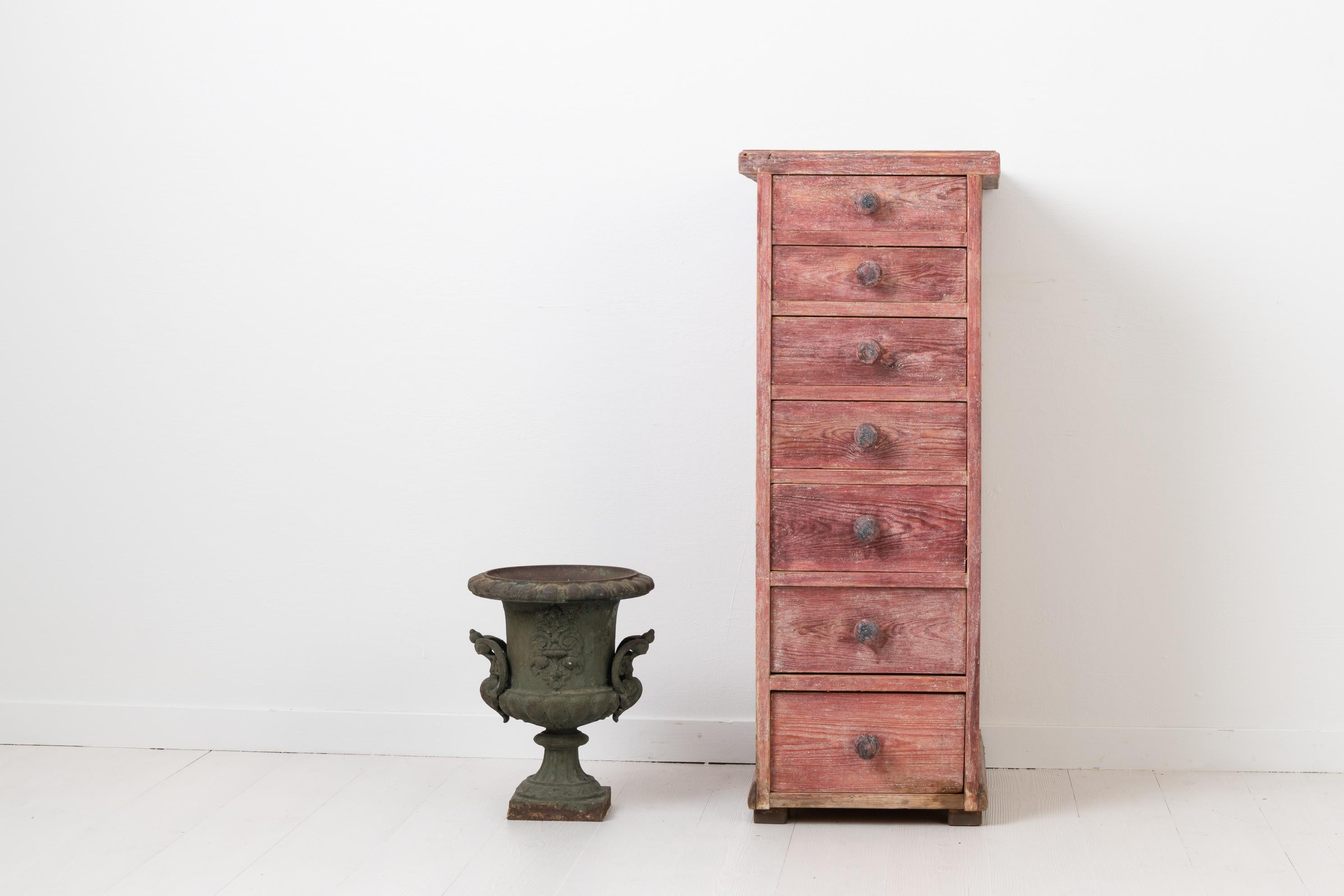 Unusually tall and narrow chest of drawers. The chest is made in painted pine with old distressed paint and authentic patina. Original wooden knobs on each drawer. Made in Sweden during the years circa 1880-1890. Healthy and solid frame.
   