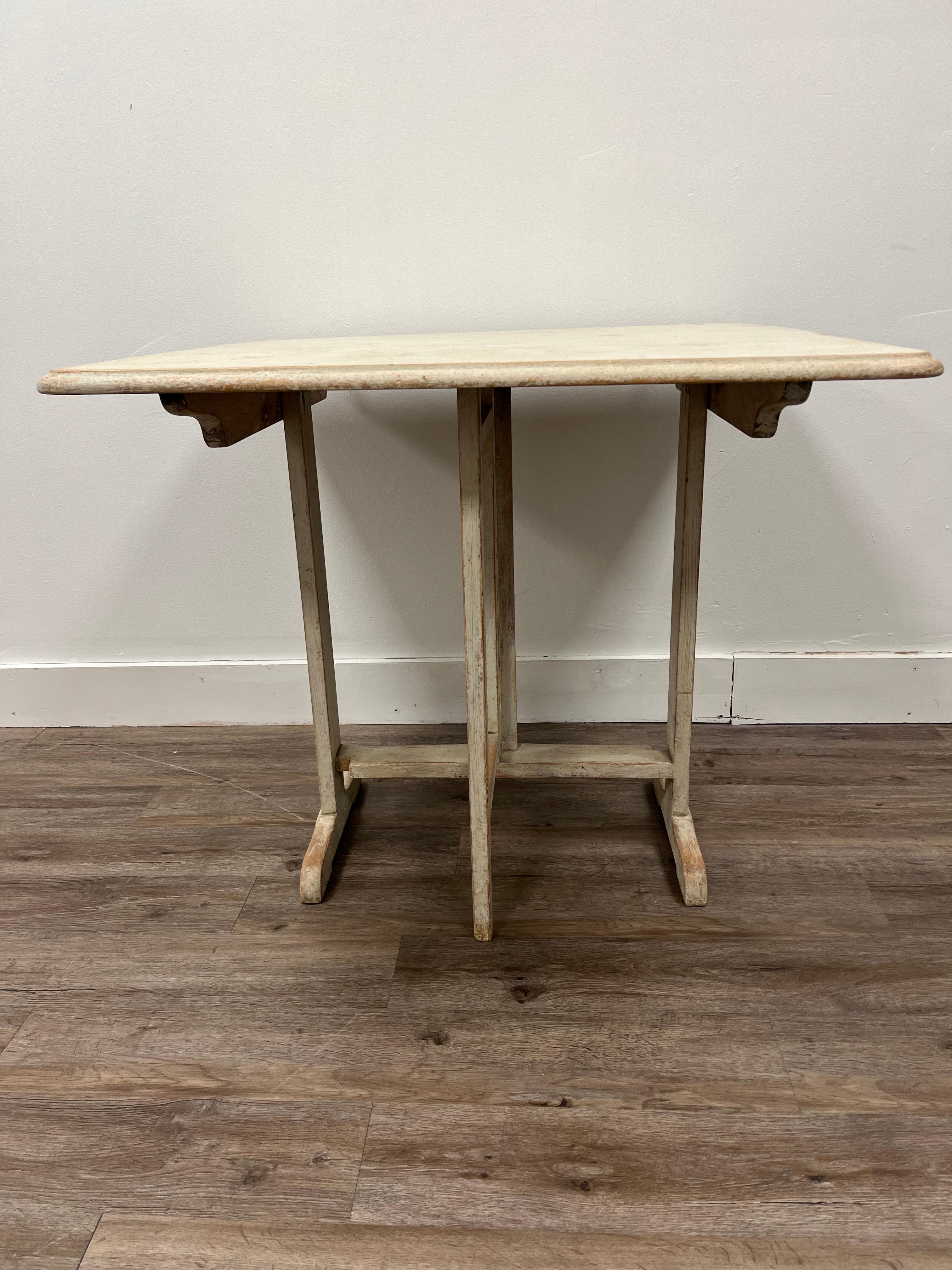 A Swedish tilt top gate leg table. Highly functional for small spaces. Can seat up to four chairs. Repainted in cream color. 