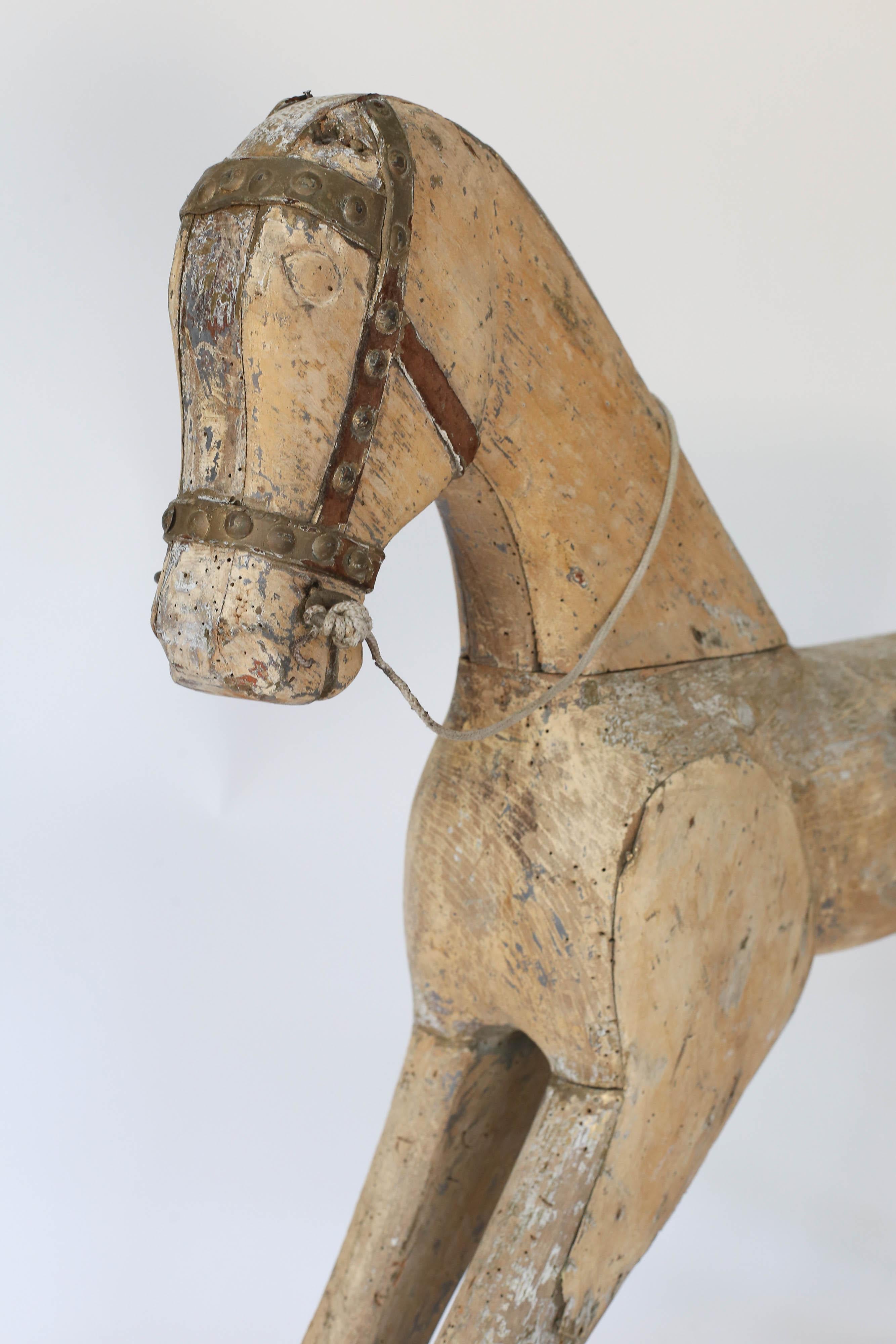 A 19th century carved and painted wooden toy horse from Sweden. A truly loved piece with a metal bridle, ears and tail have been lost through the years of love.