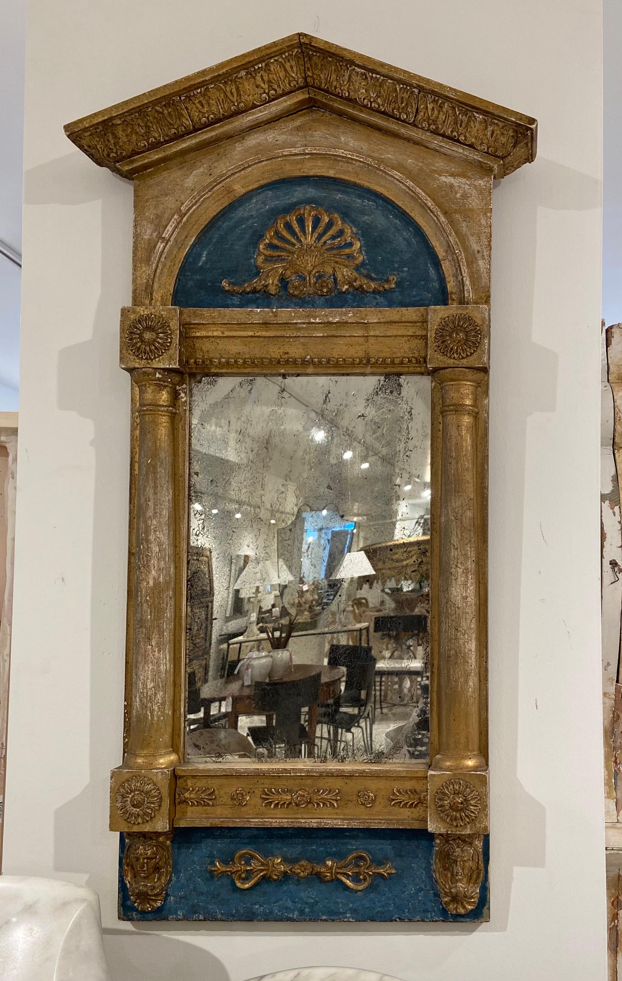 This antique Swedish mirror is from the 1830s. It is painted turquoise and gold with neoclassical carvings. 
