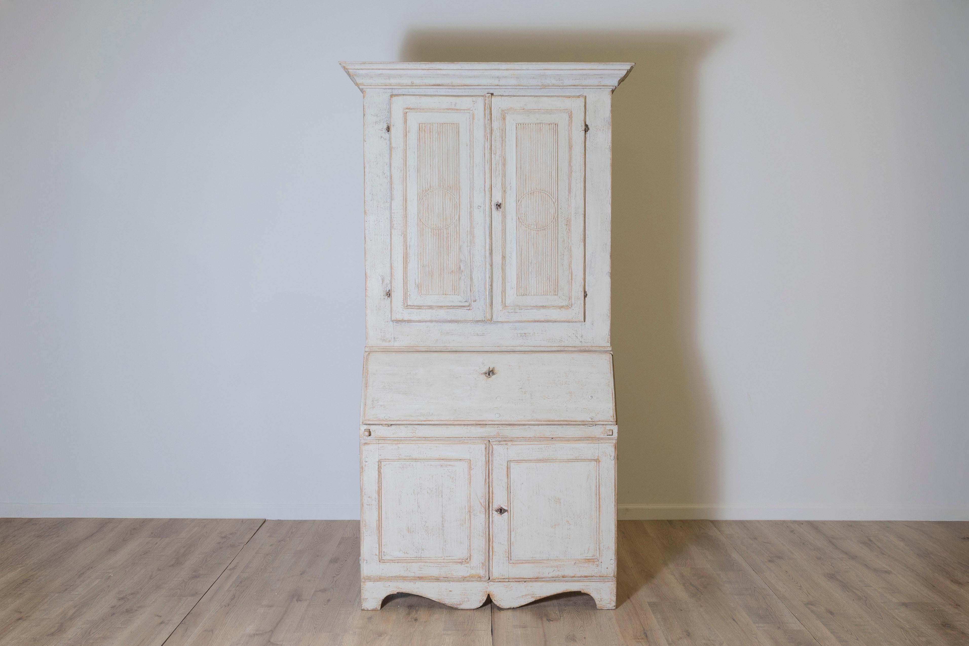 Ce bureau gustavien du début du 19e siècle est une étonnante pièce en deux parties qui allie l'aspect pratique à l'élégance suédoise classique. Fabriqué en pin, il présente une douce patine blanche vieillie qui rehausse son caractère ancien et
